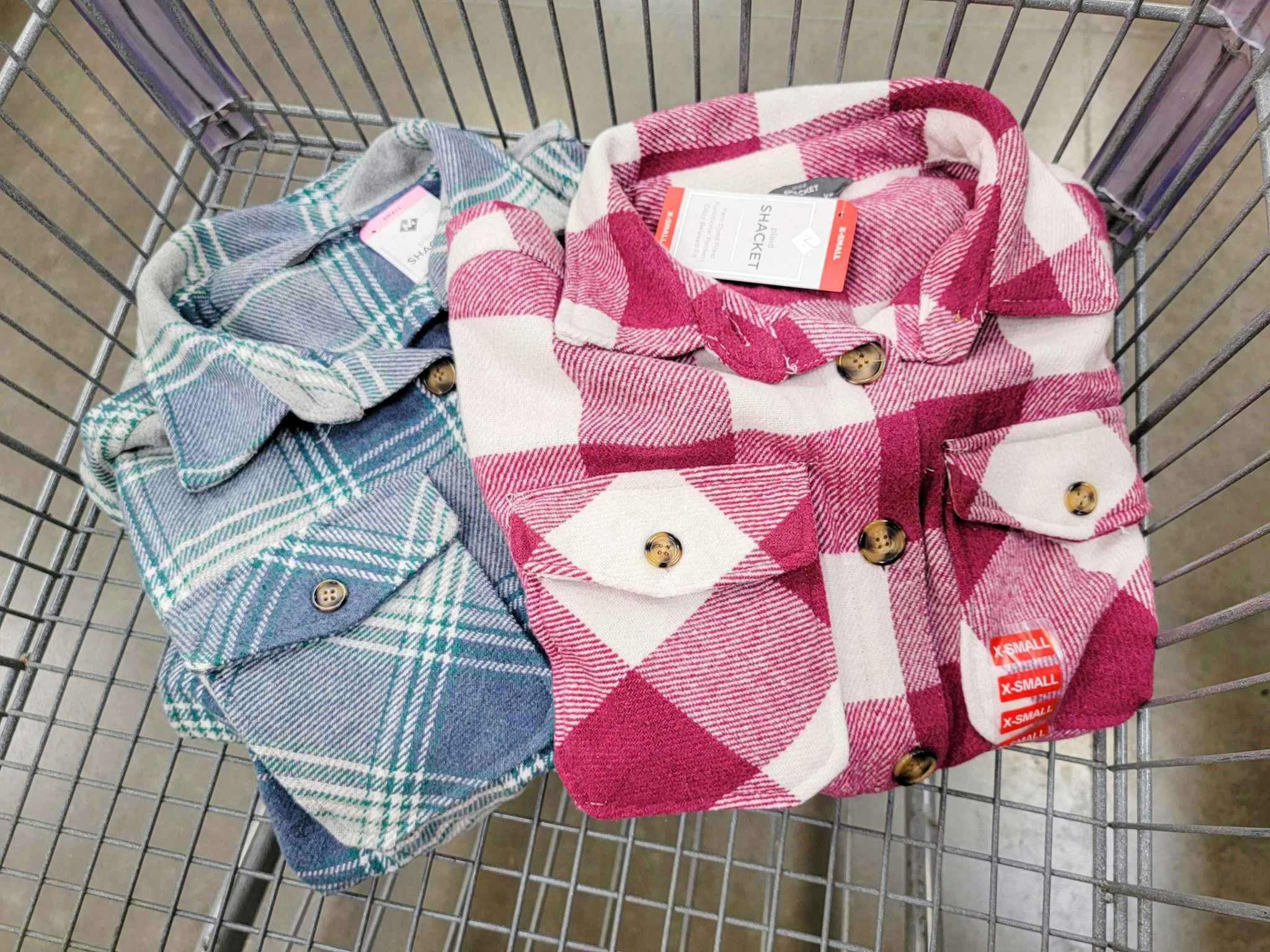 2 ladies shackets in a cart, one is blue plaid one is pink plaid