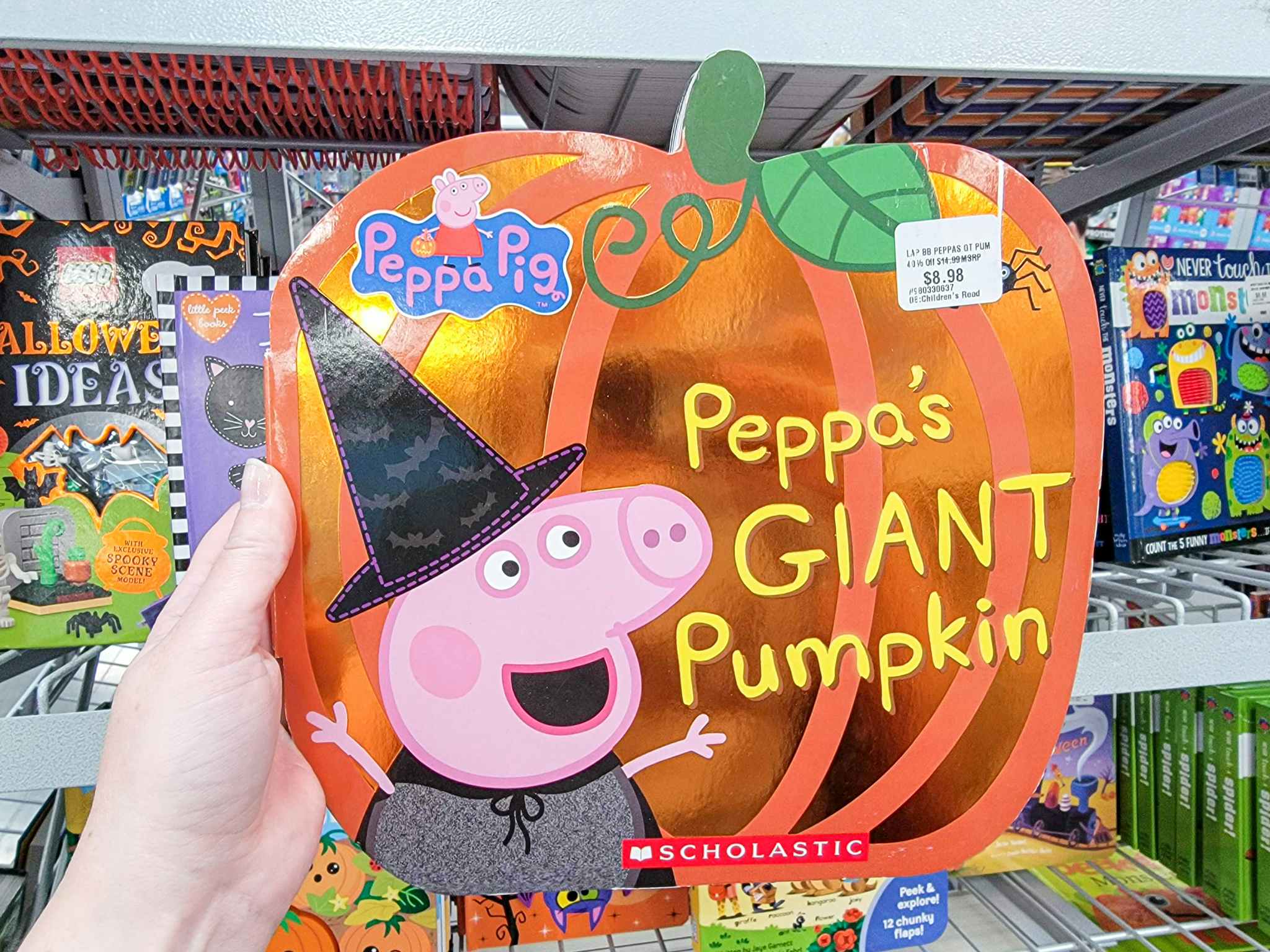 hand holding a peppa's giant pumpkin book