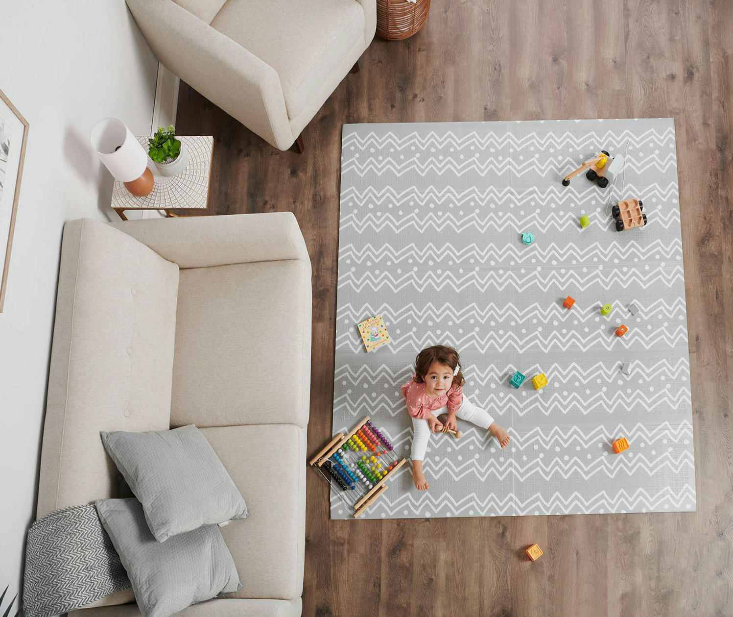 a baby playing on a grey with white chevron print foam play mat
