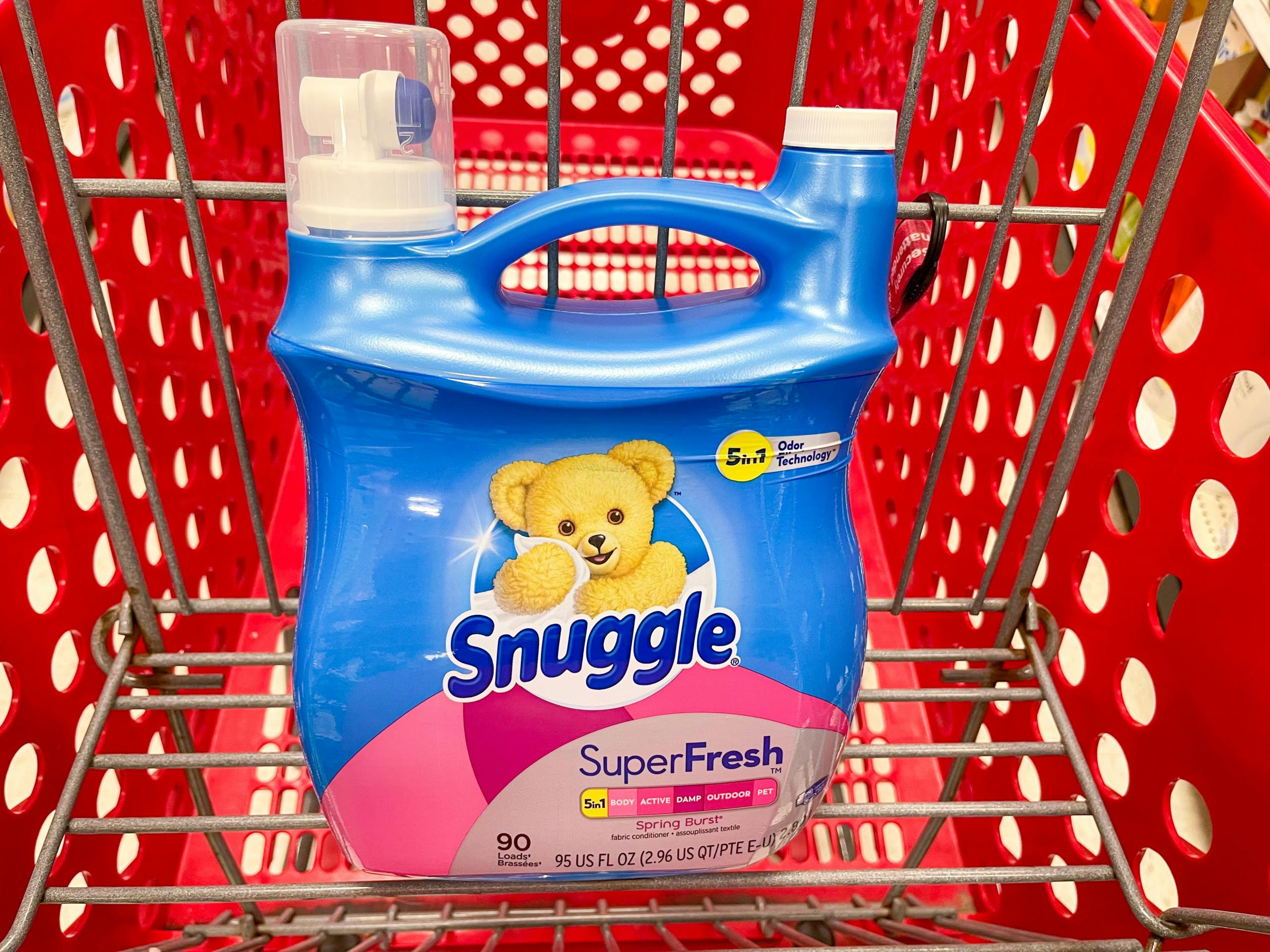 A jug of Snuggle Super fresh fabric softener sitting in a shopping cart.