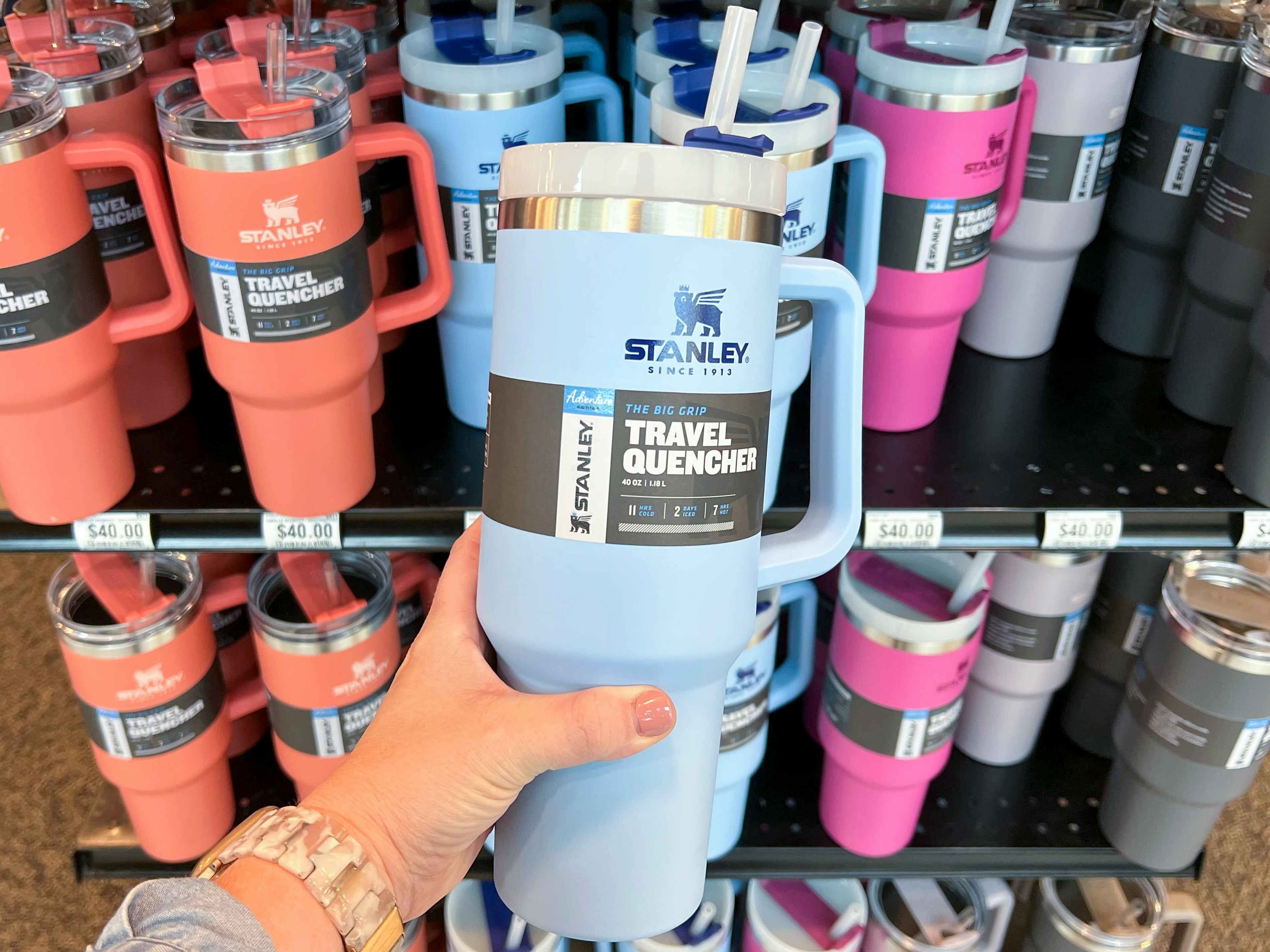 A person holding a blue Stanley quencher cup.