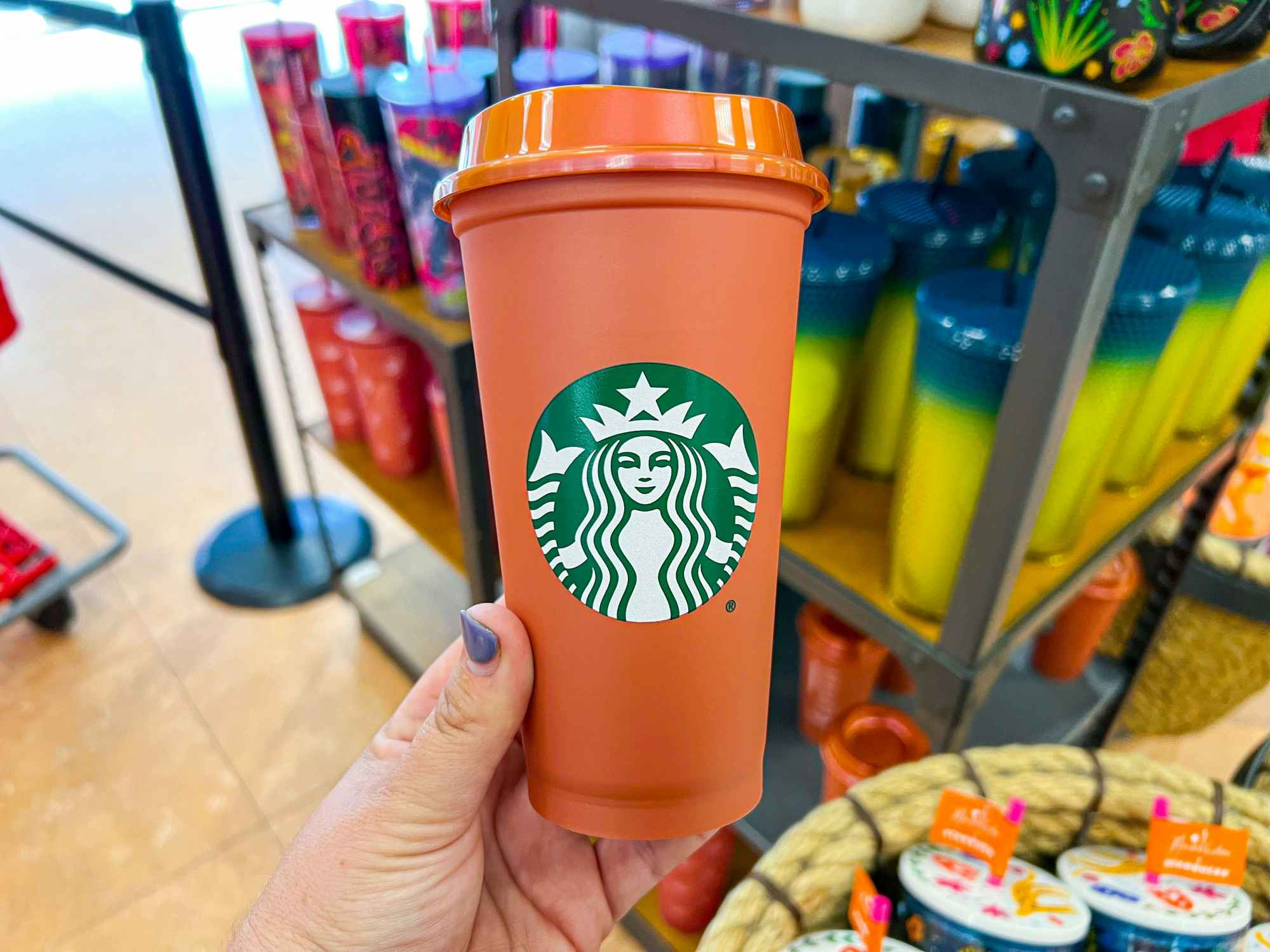 someone holding a new fall Starbucks cup in a Starbucks