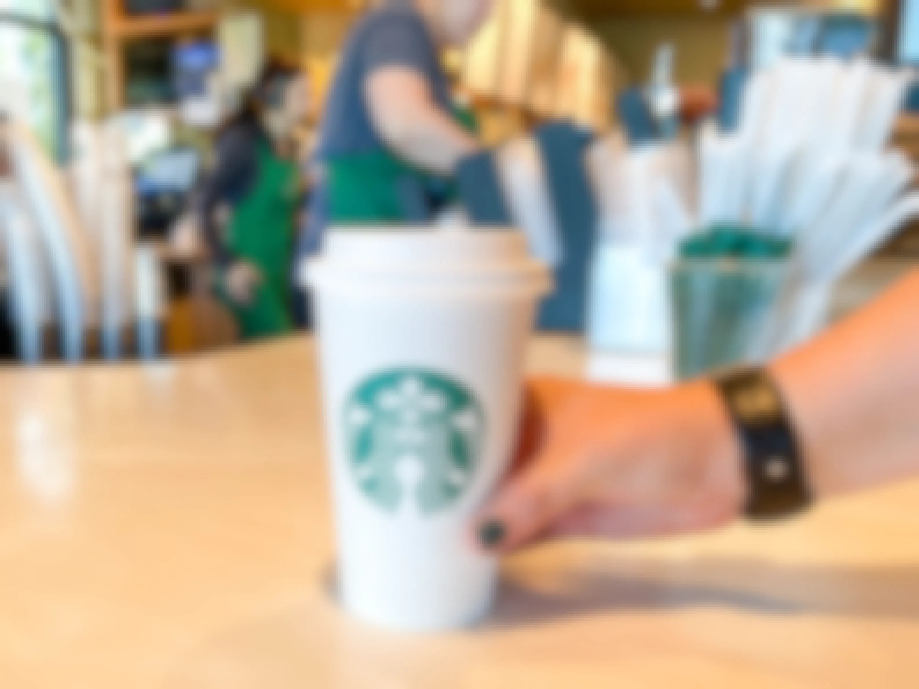 a Starbucks drink being grabbed from the counter at Starbucks