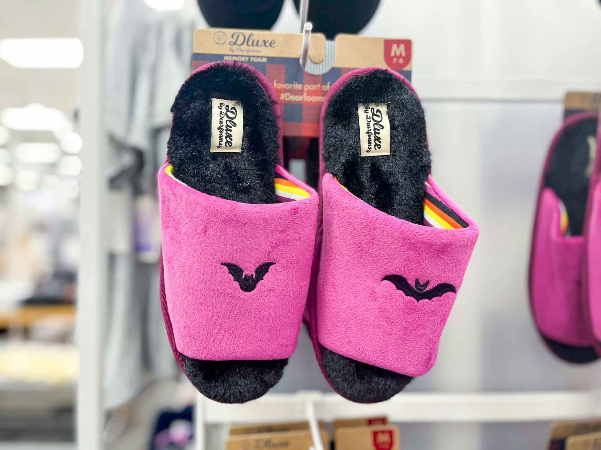 hand holding dearfoams bat halloween slippers at target