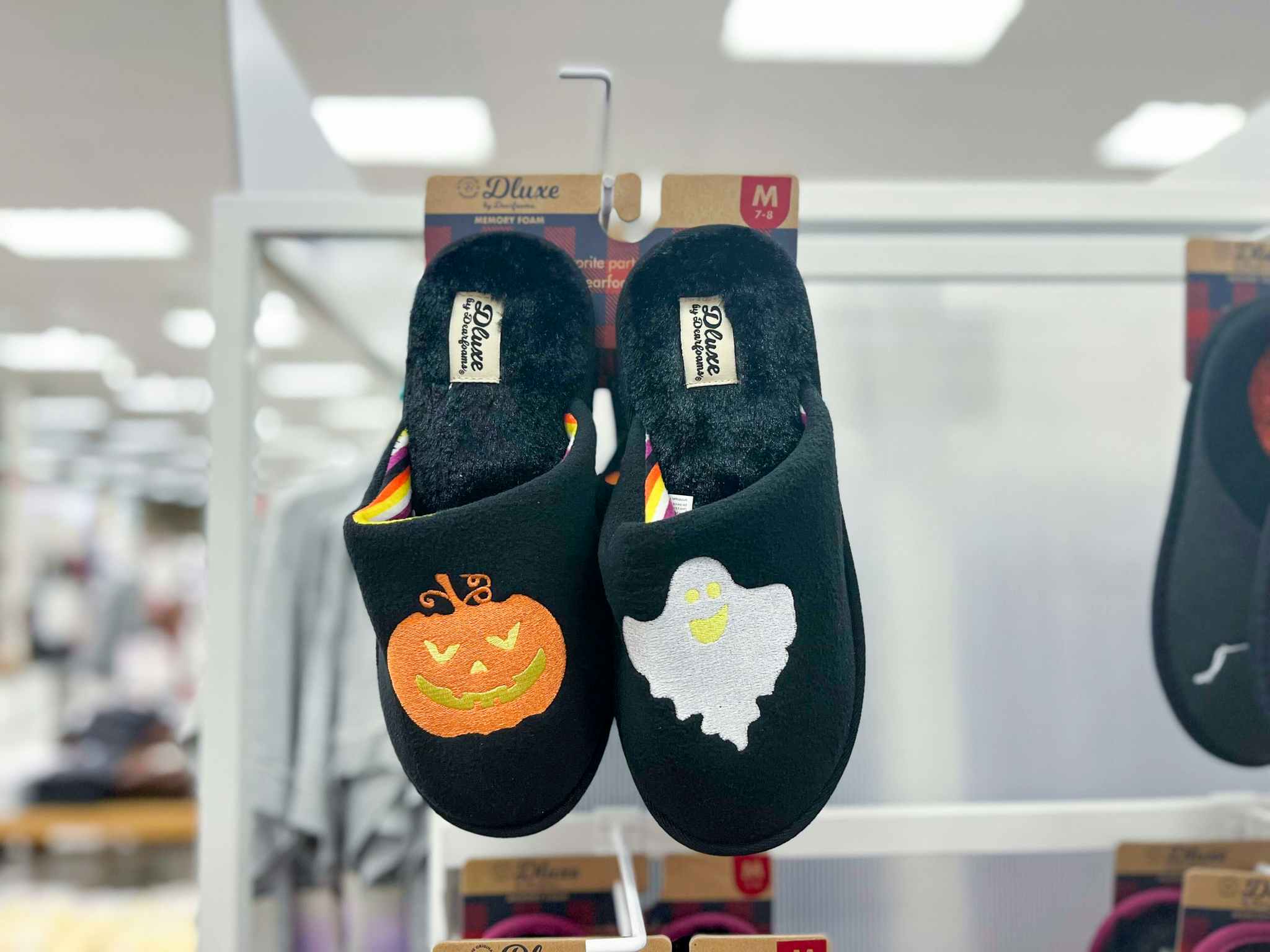 hand holding dearfoams pumpkin ghost halloween slippers at target