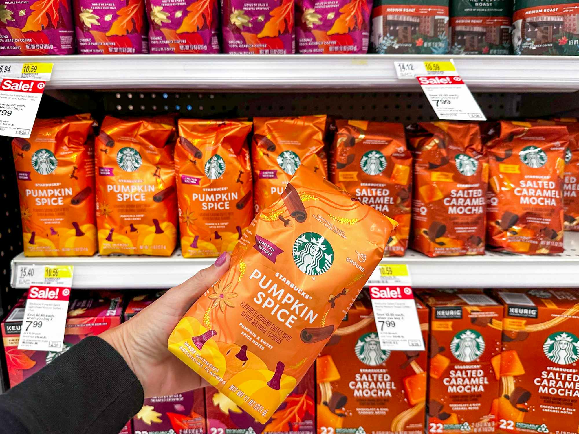someone holding a bag of pumpkin spice Starbucks ground coffee at Targetpkin spice coffee at Target