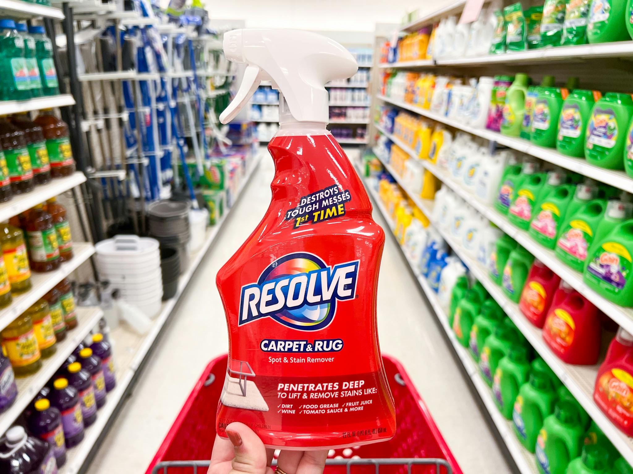 A hand holding a bottle of Resolve Stain Remover in an aisle at Target
