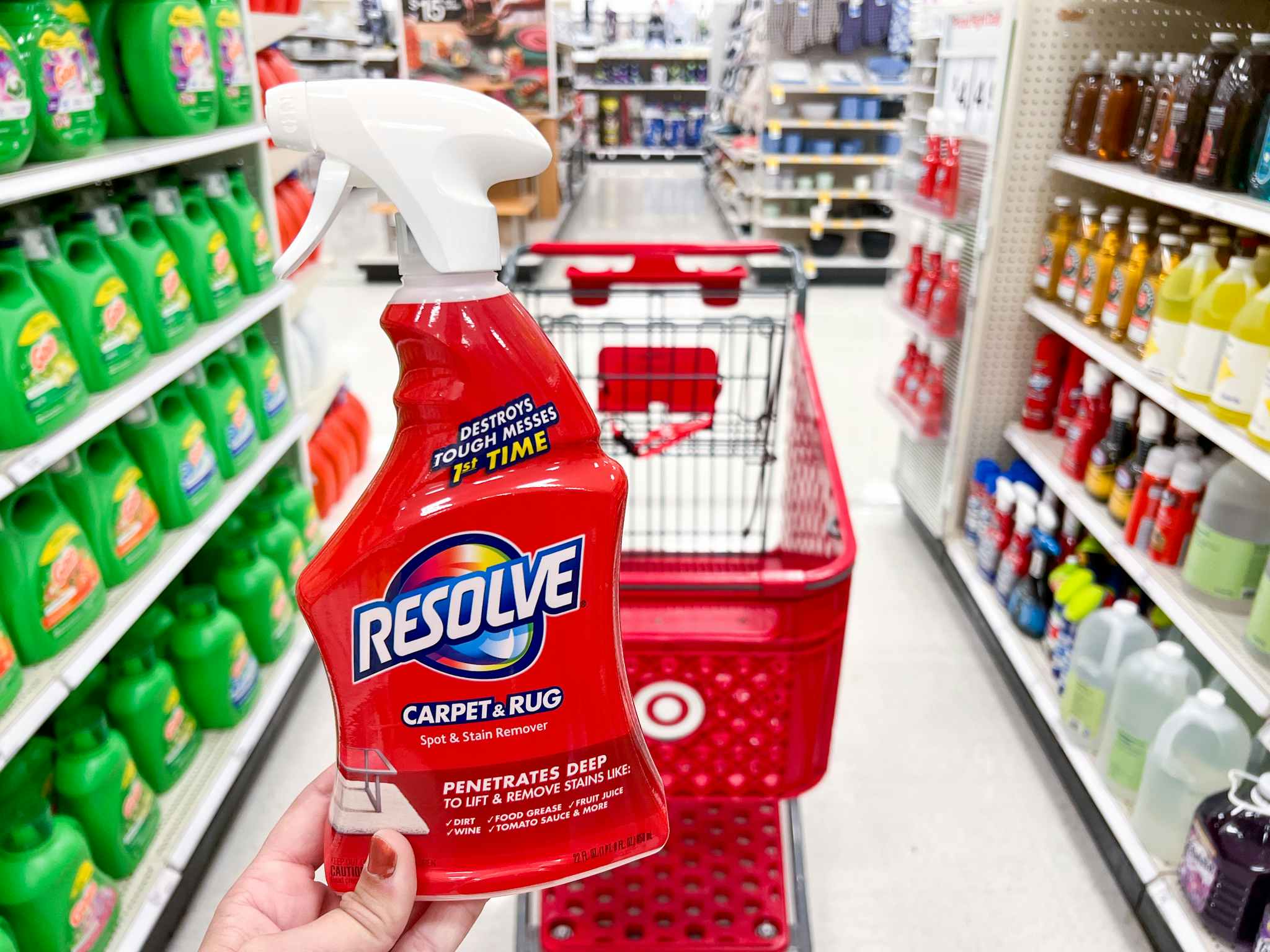 A hand holding a bottle of Resolve Stain Remover in an aisle at Target