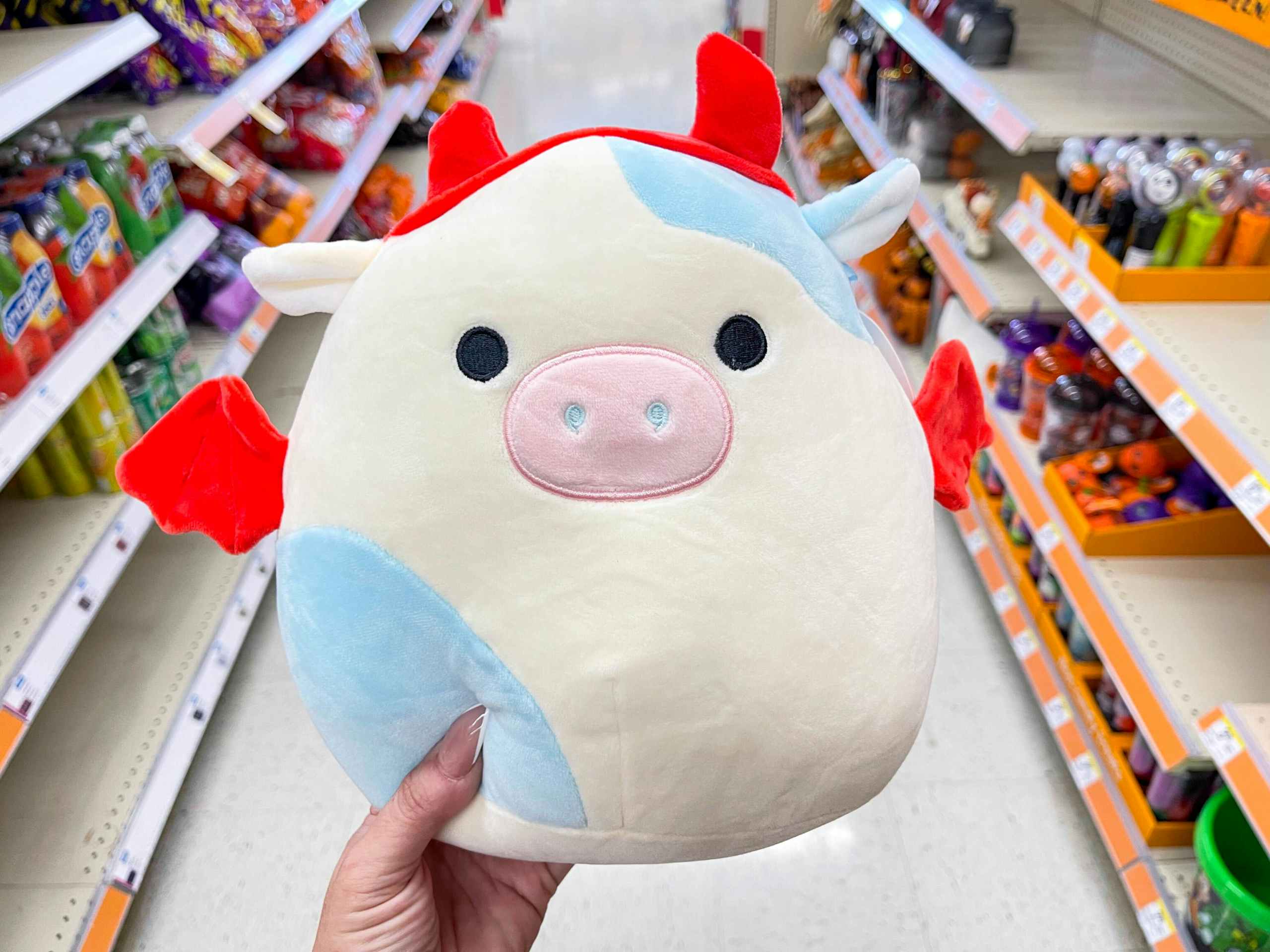 hand holding Belana the cow devil Squishmallow