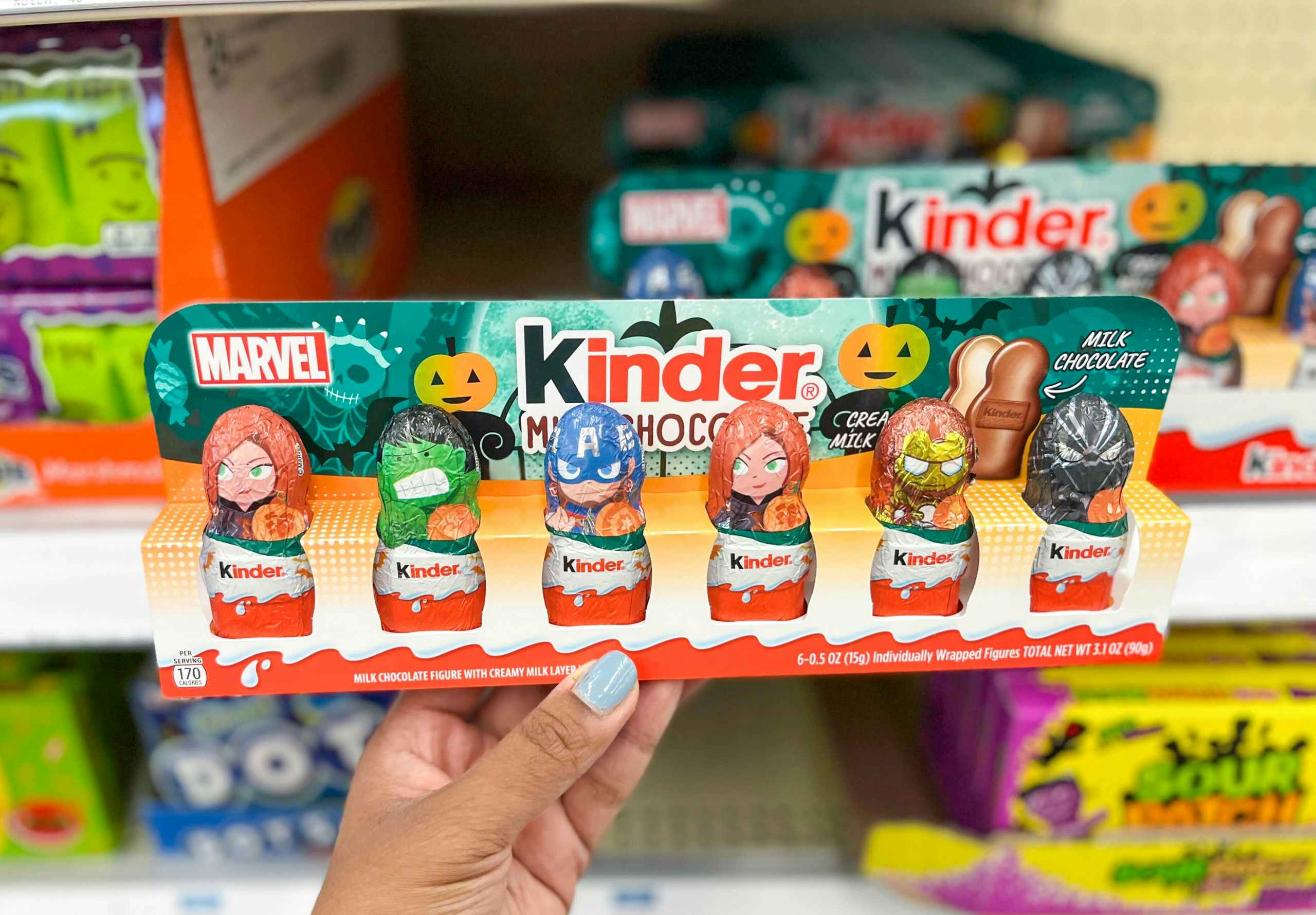 hand holding pack of Marvel Avengers Kinder milk chocolates in aisle