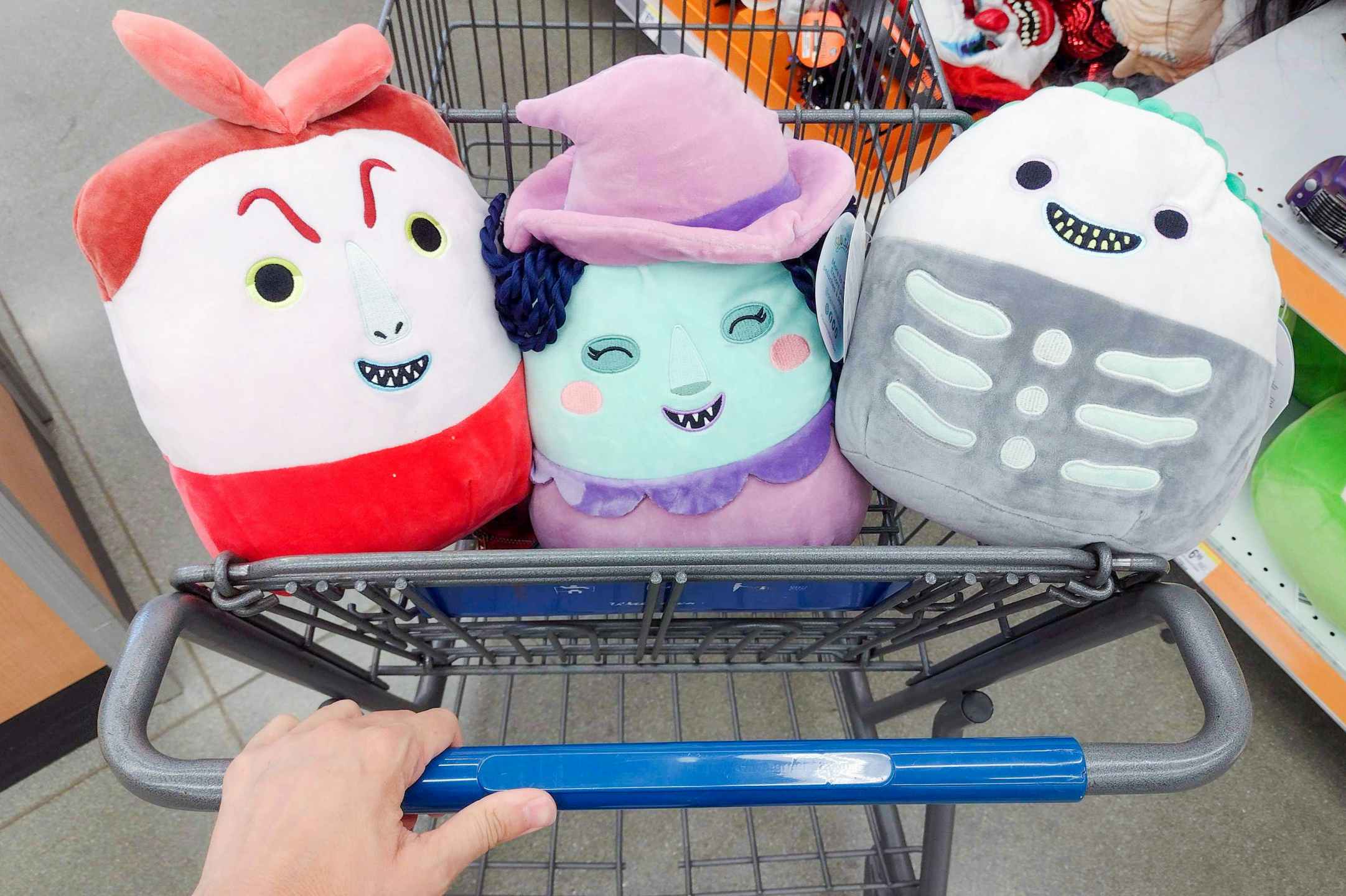 hand pushing cart with Lock, Shock, and Barrel Nightmare before Christmas Squishmallows inside