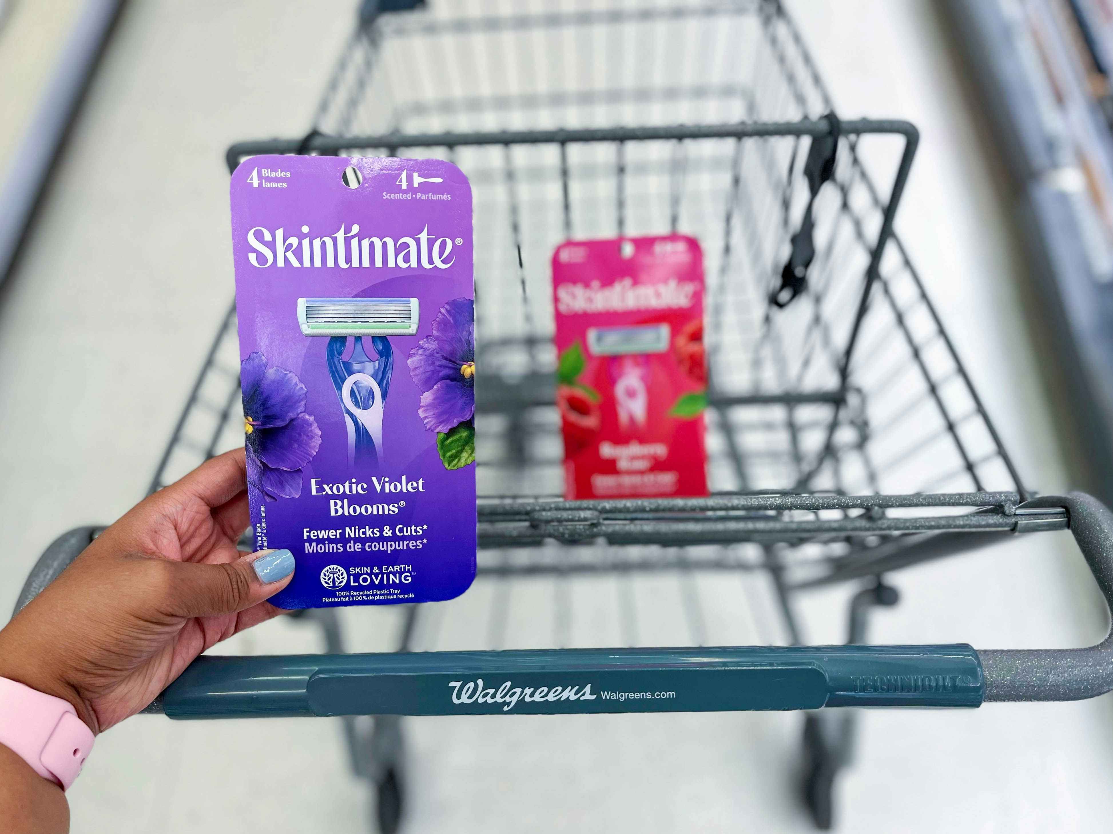 hand holding pack of Skintimate disposable razors in front of another pack in shopping cart