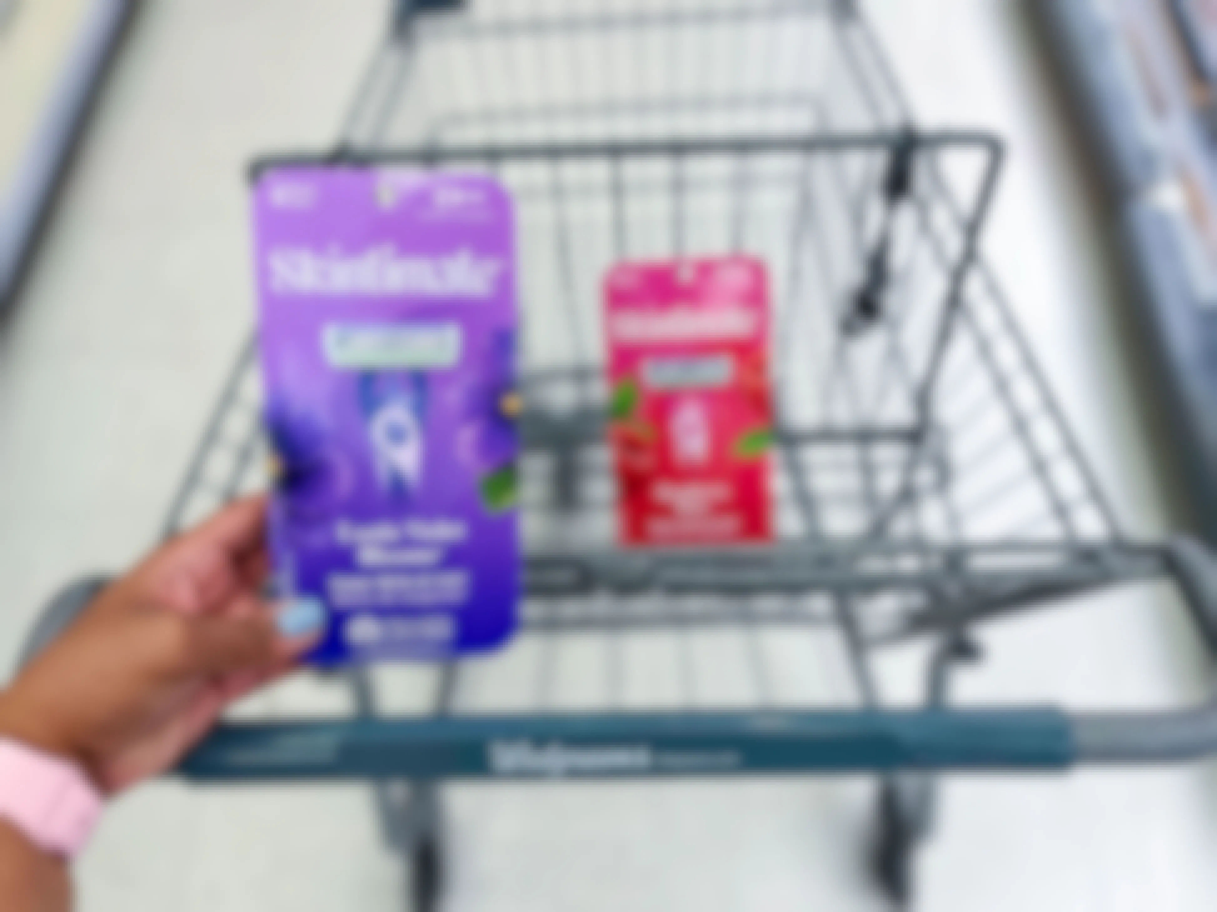 hand holding pack of Skintimate disposable razors in front of another pack in shopping cart