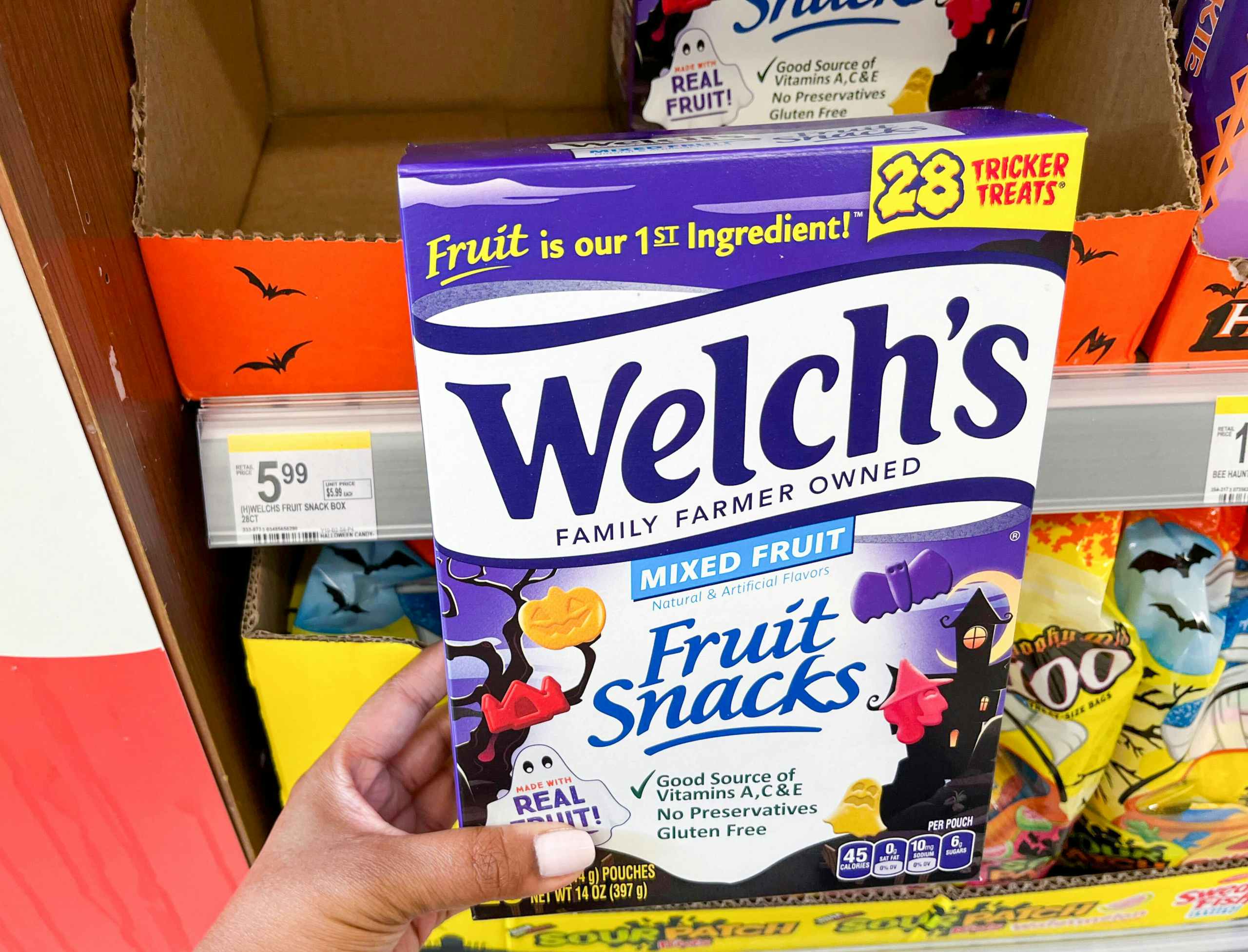 hand holding box of Welch's fruit snacks next to price tag