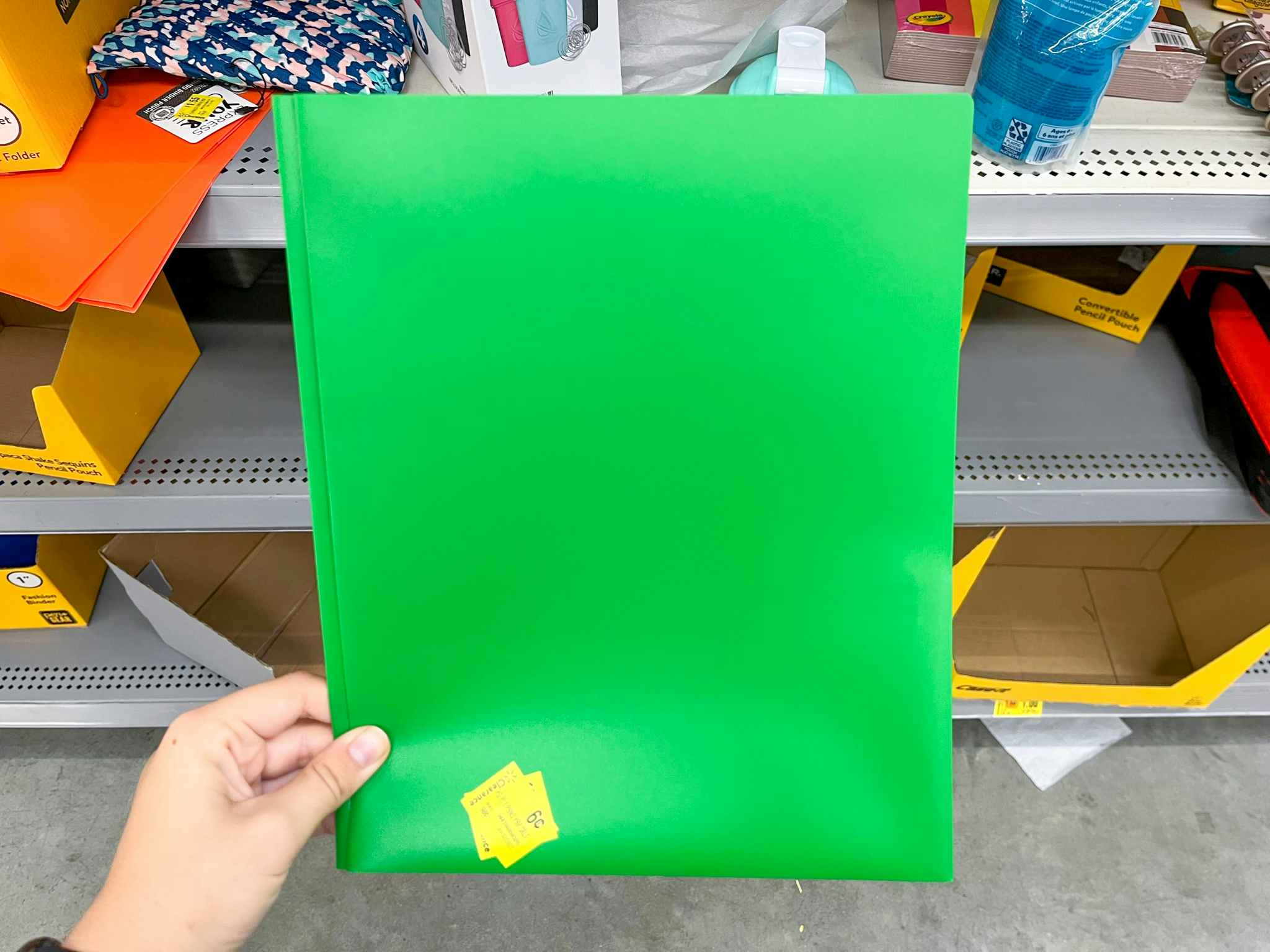 hand holding pen + gear green folders at walmart