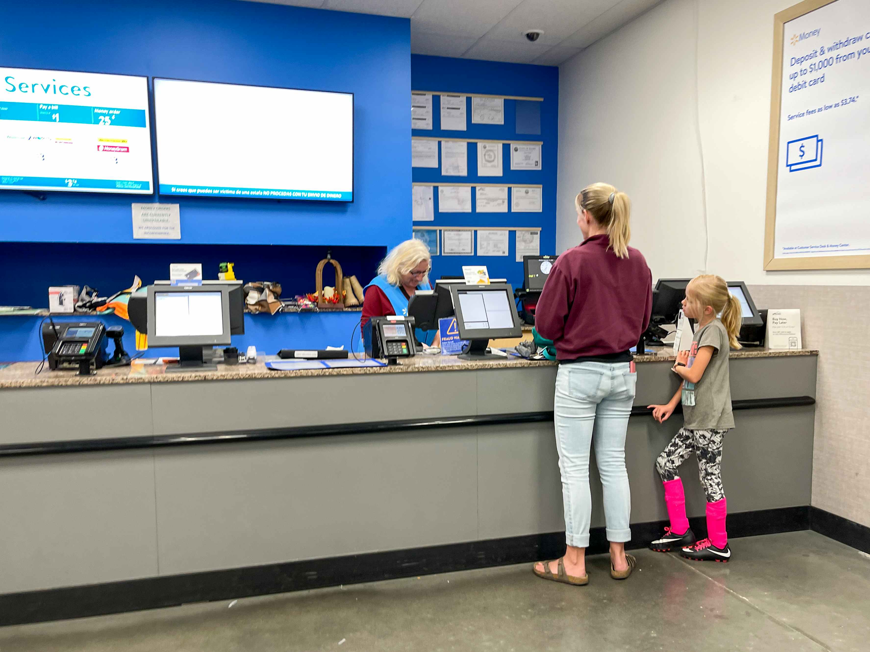 A parent and child standing together at the Walmart customer service desk