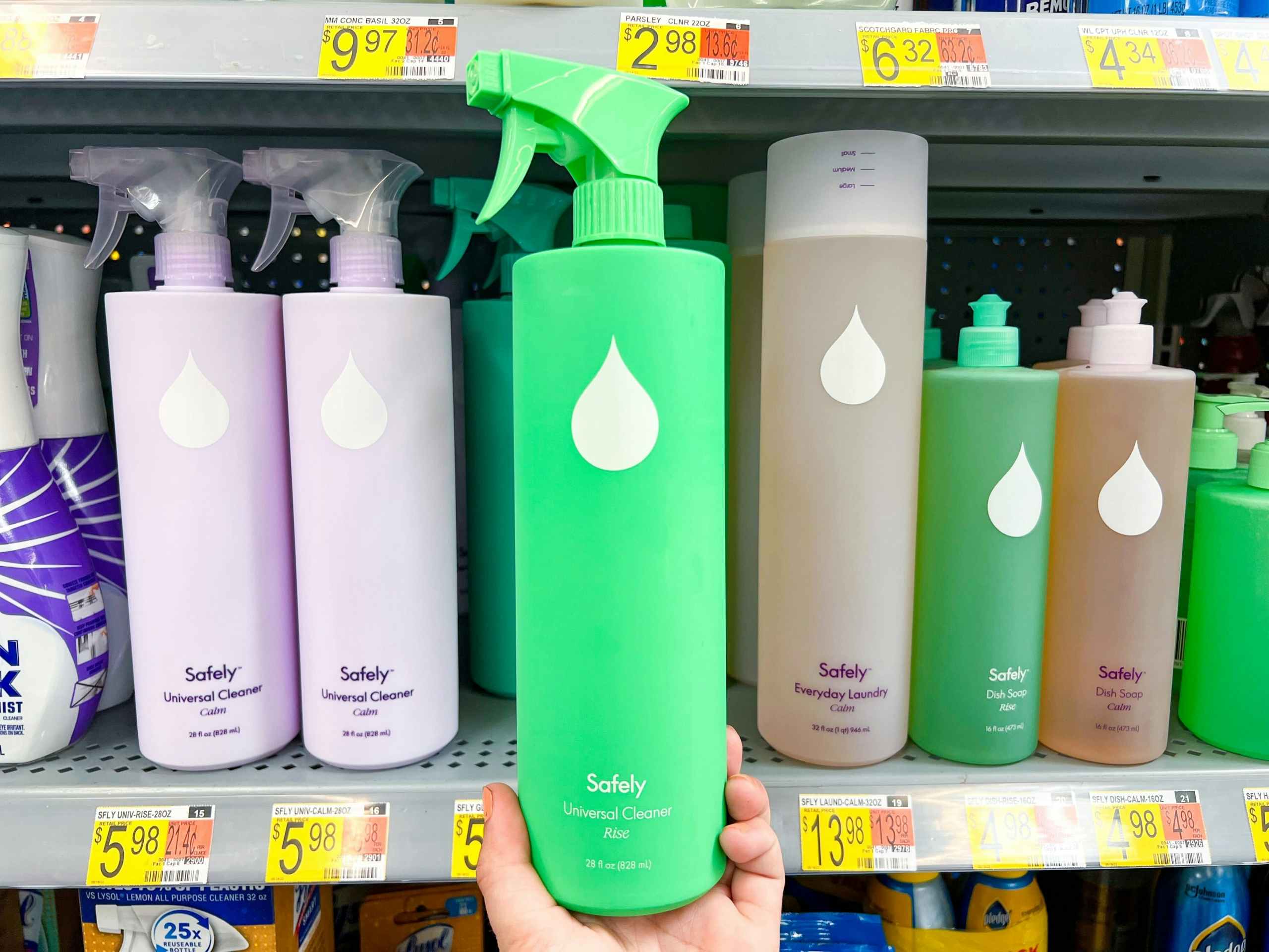 hand holding a bottle of Safely Universal cleaner in front of a Walmart shelf holding like items