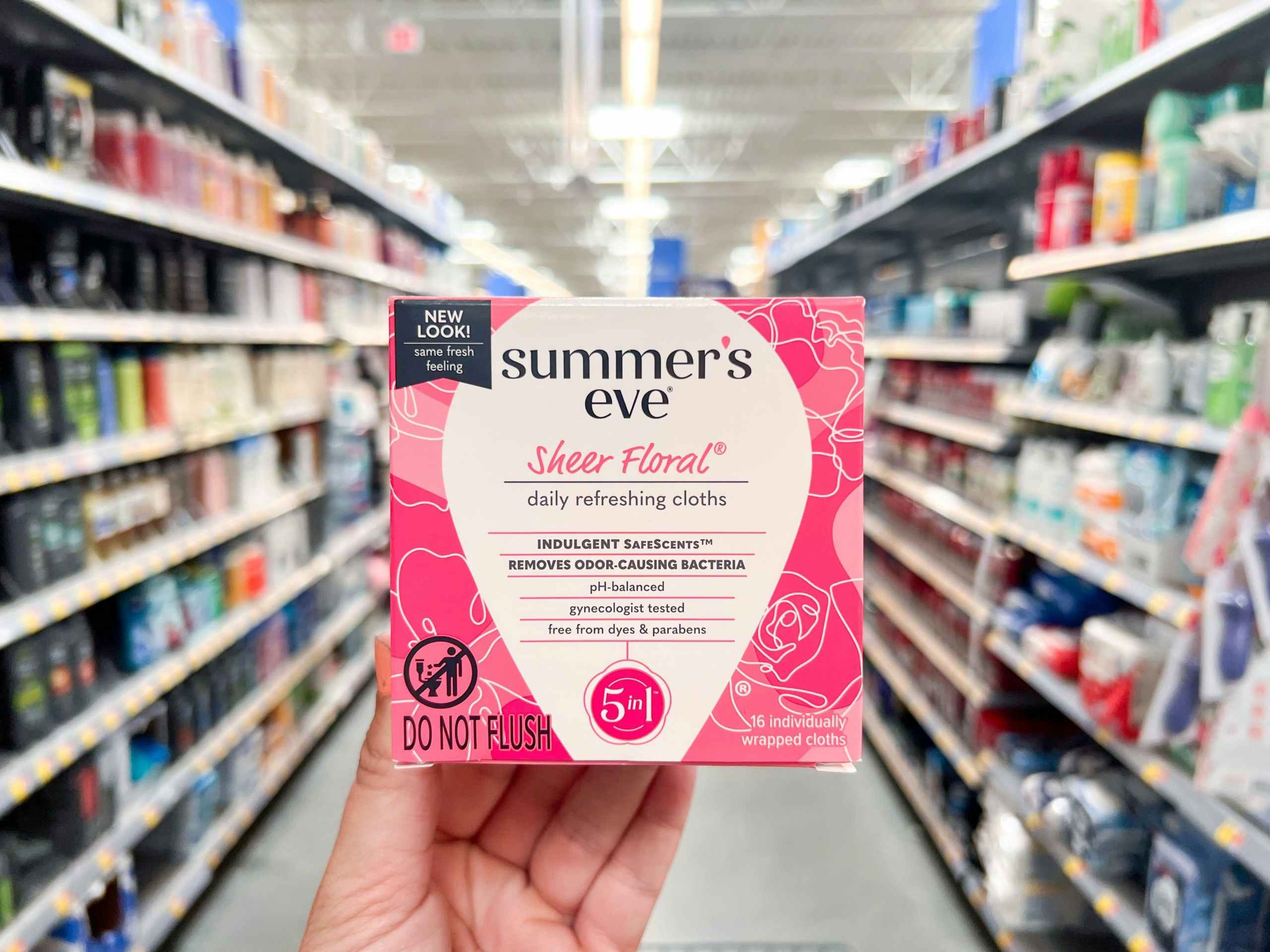 hand holding a box of Summer's Eve feminine wipes in a Walmart aisle
