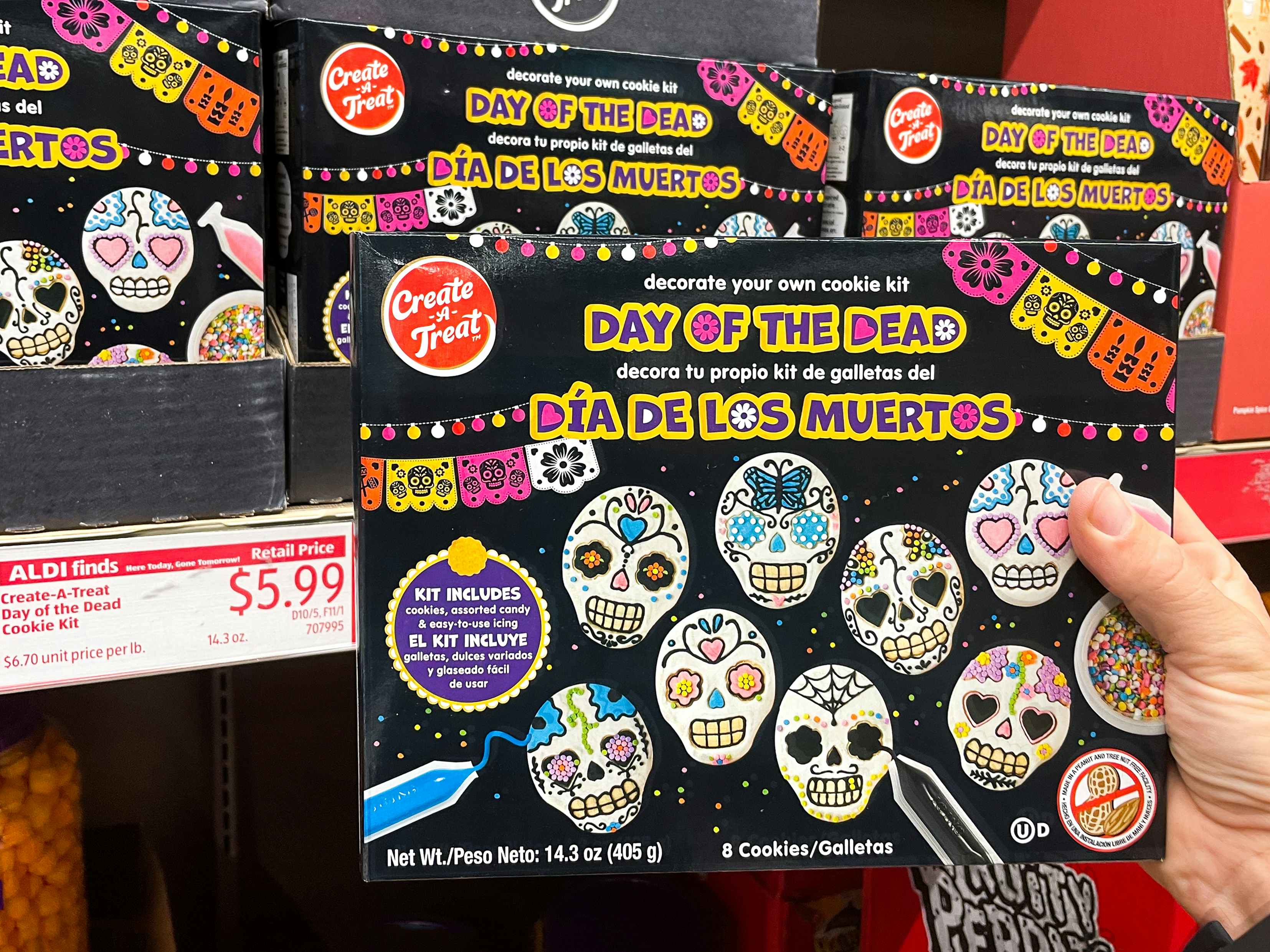 A person's hand holding a Halloween Day of the Dead cookie decorating kit in Aldi.