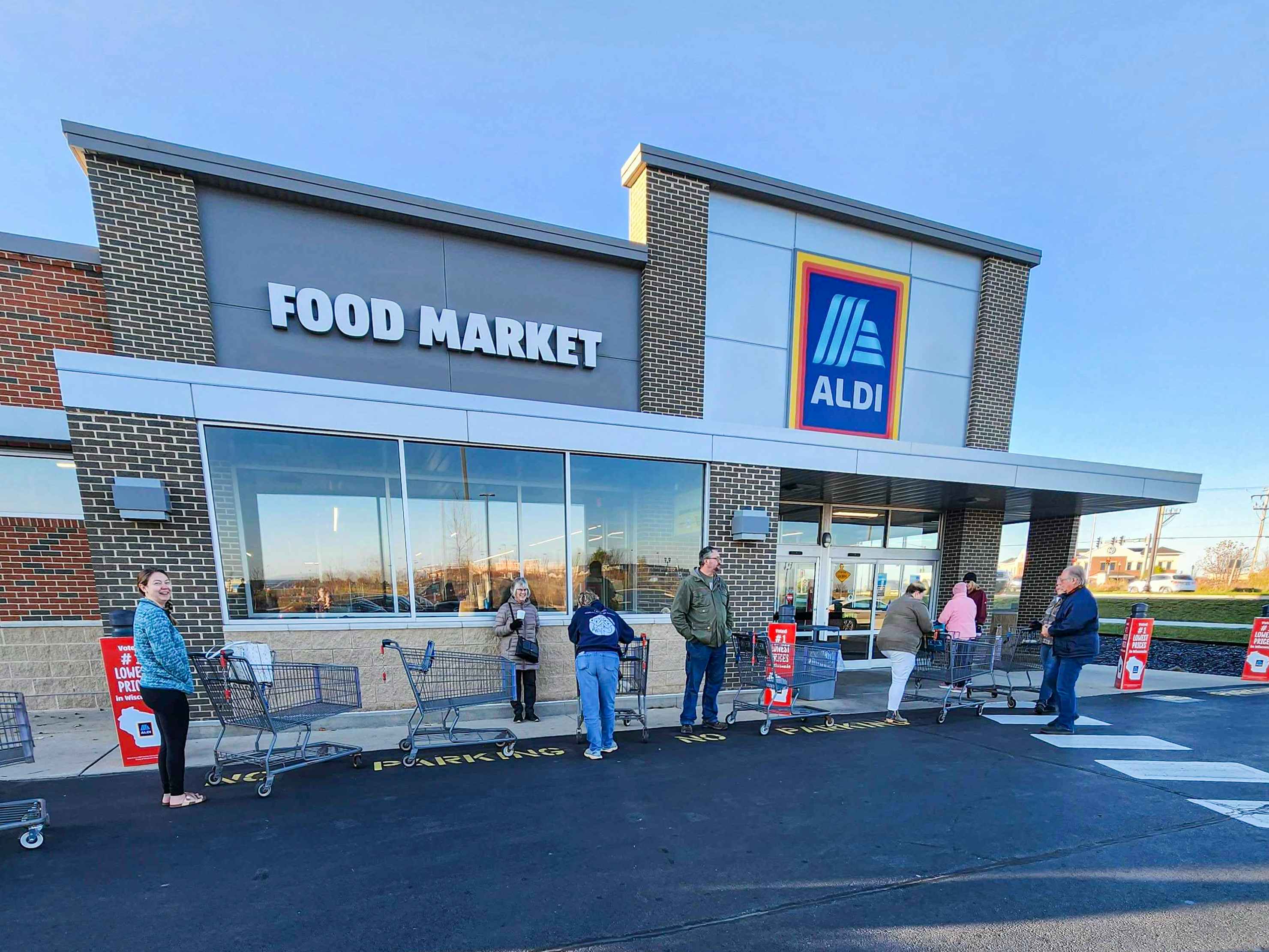 Line of people waiting outside Aldi with carts