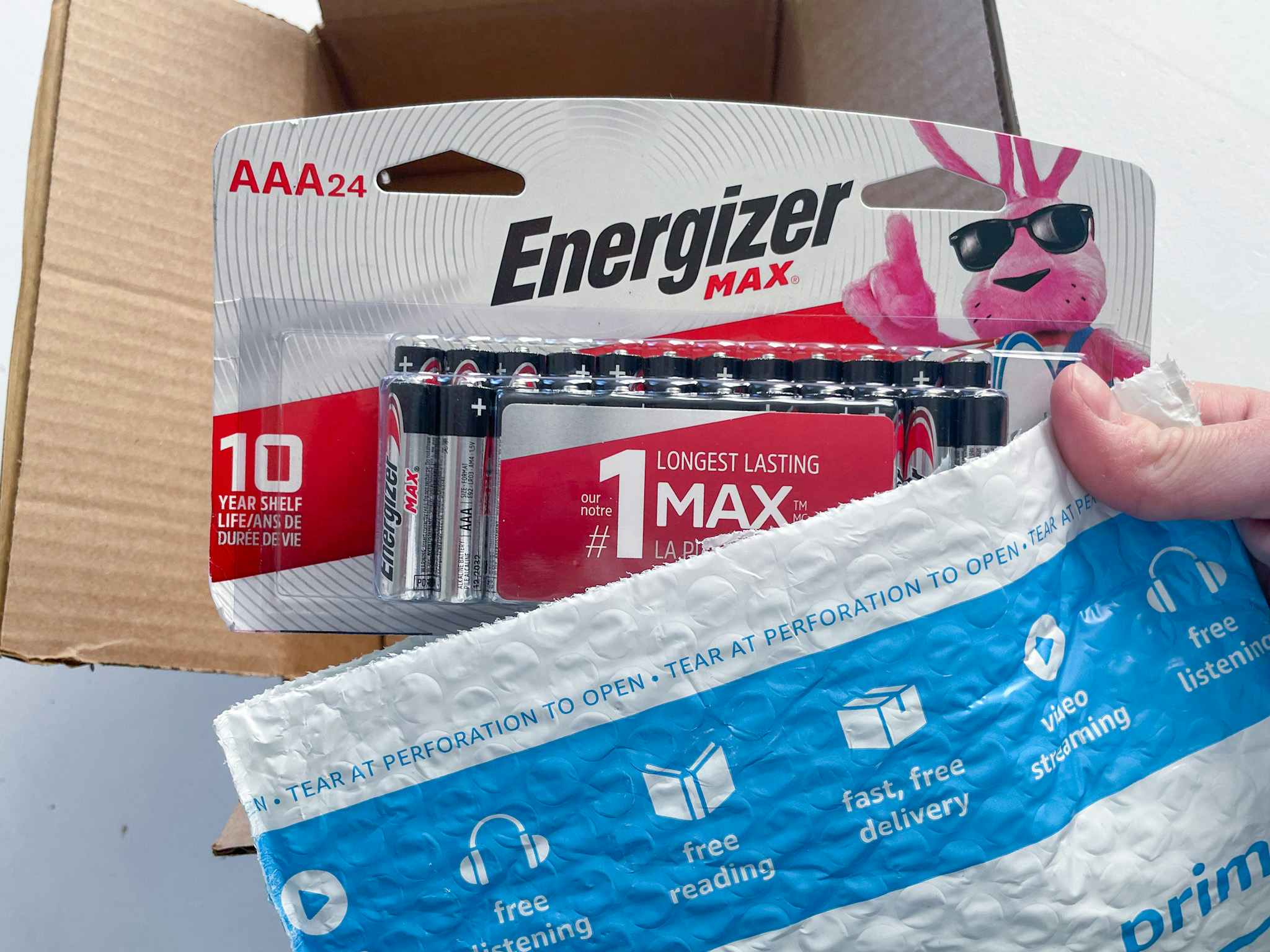 A person holding Energizer batteries with an amazon package.