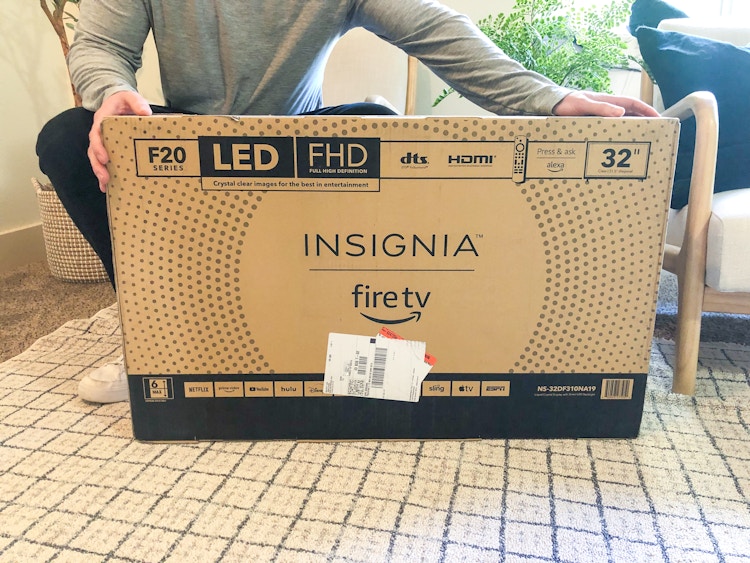 A person holding an insignia fire tv from Amazon