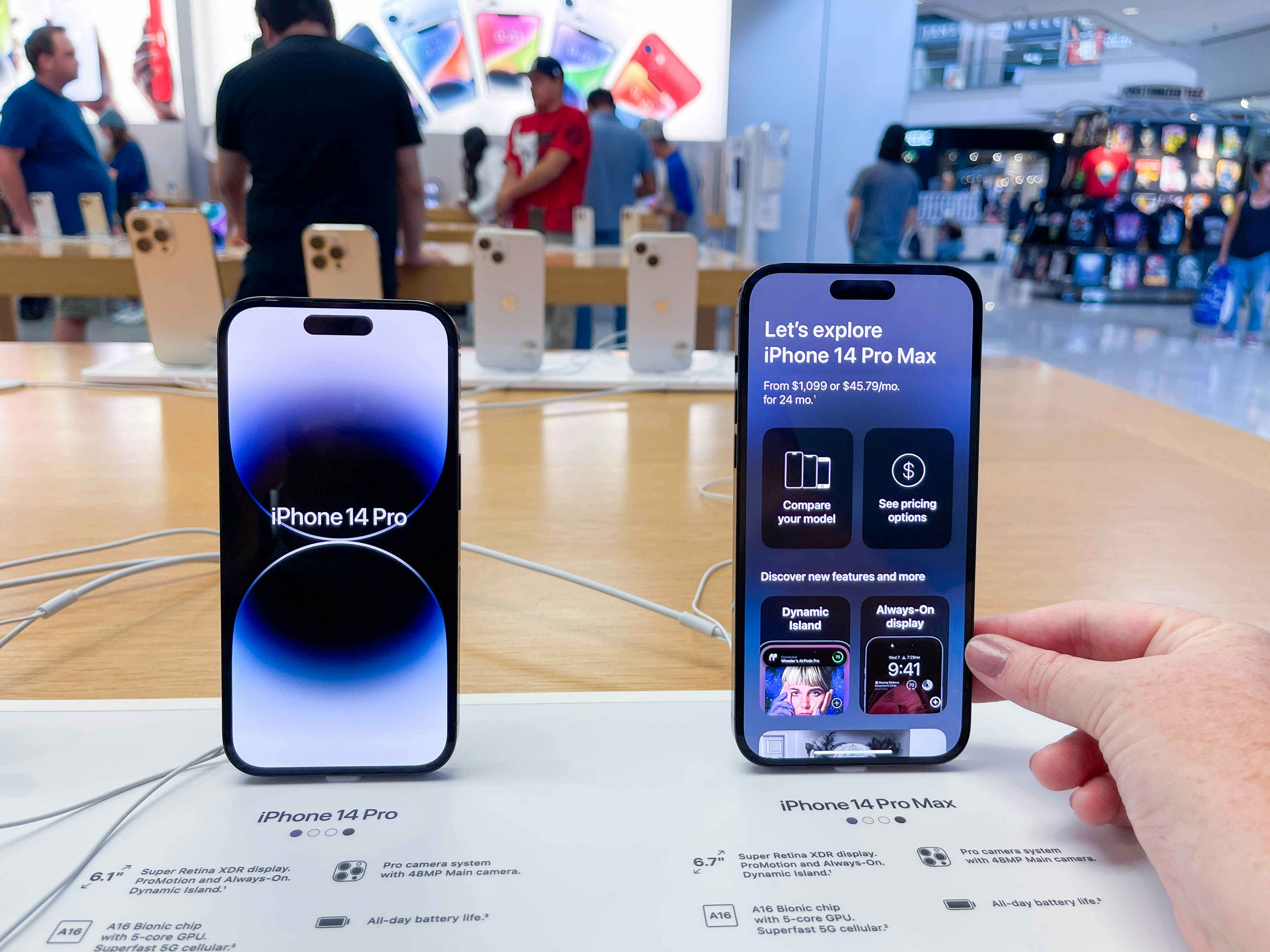 a person's hand holding a new iphone on display