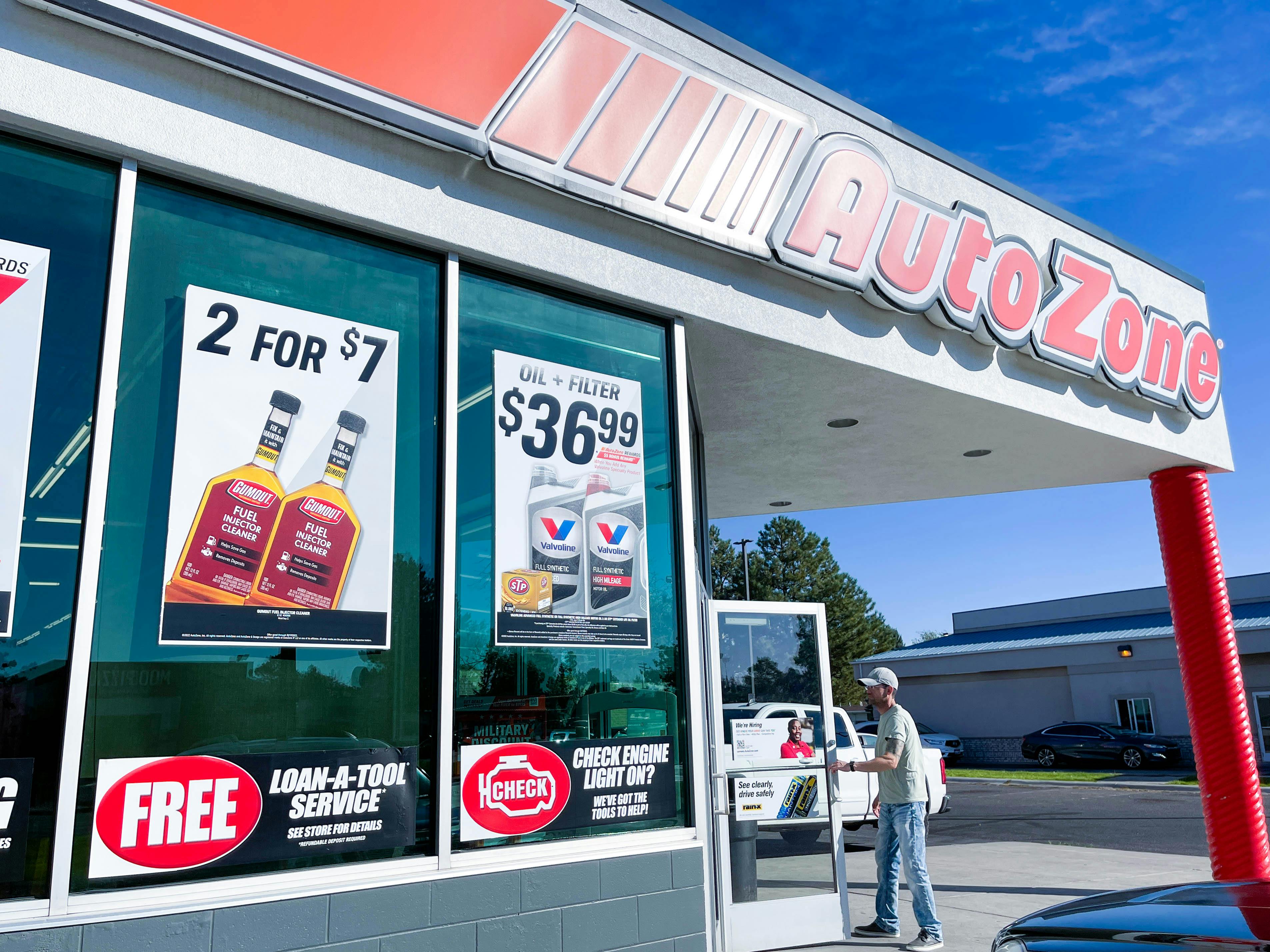 a man opening door to go inside an autozone store