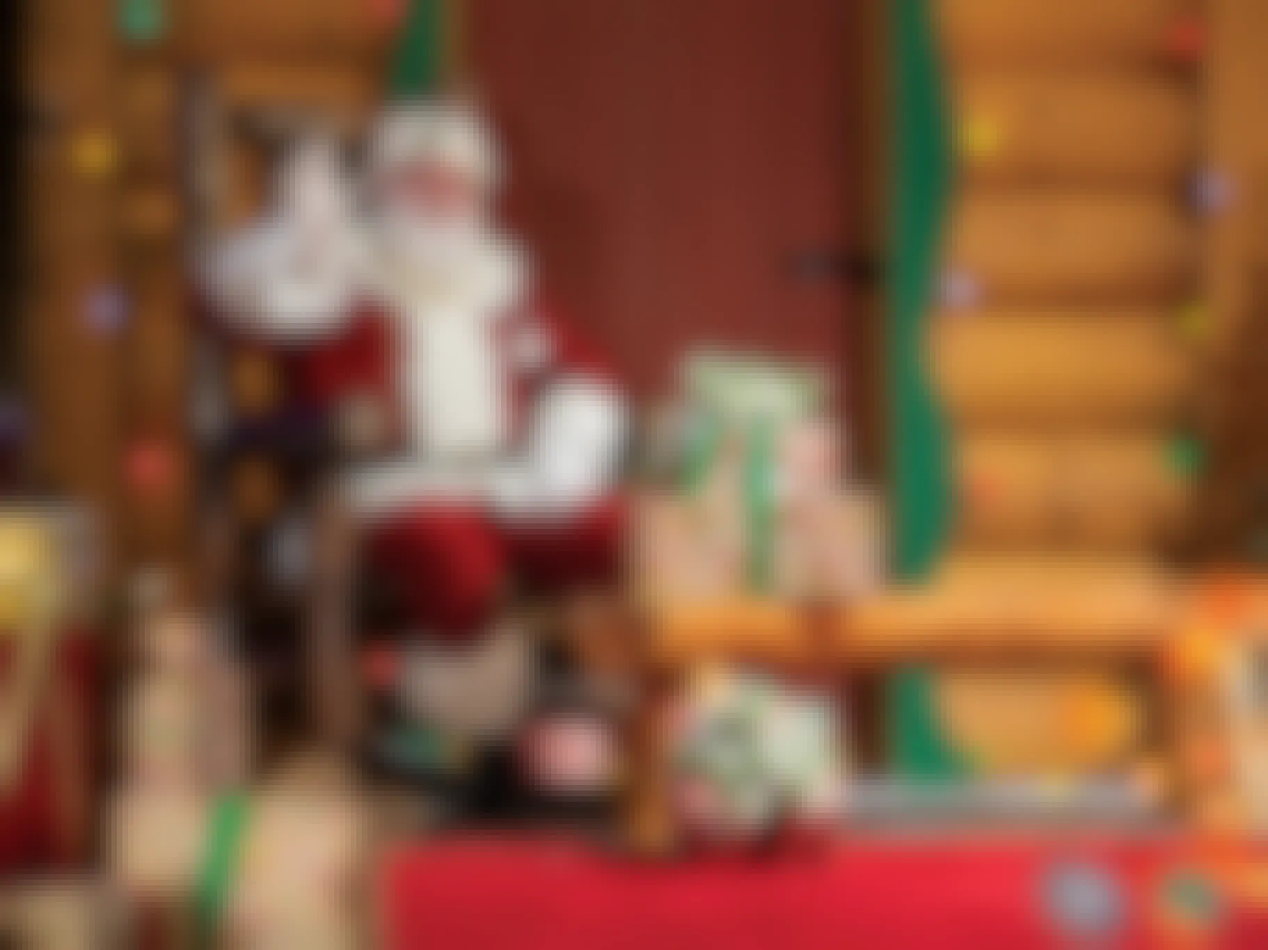 Santa sitting on a chair in the Santa's Wonderland set inside of a Bass Pro Shops store