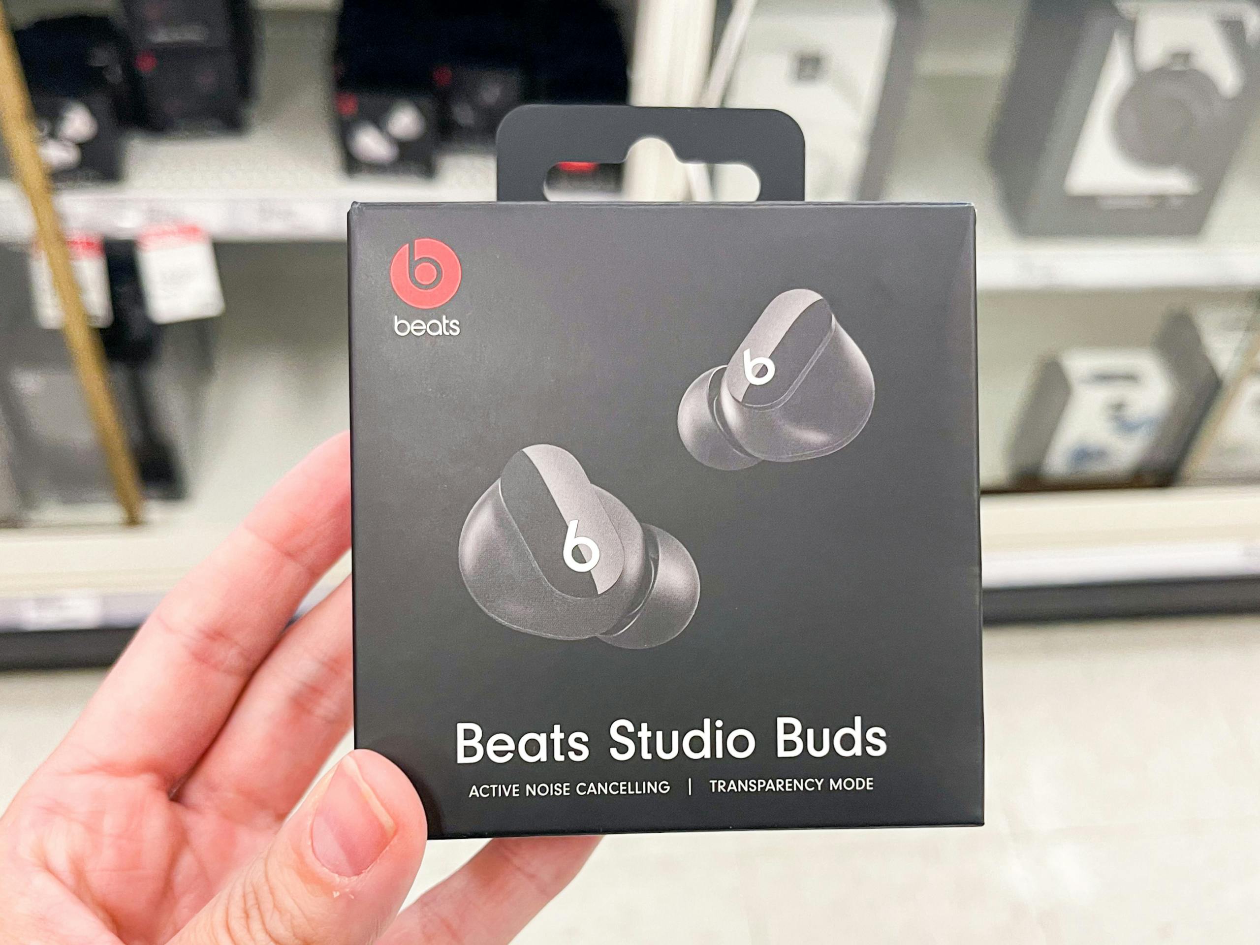 A Beats Studio Buds held out by hand.