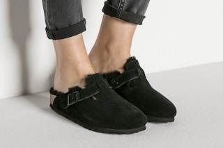 A model wearing some Birkenstock Boston clogs on a neutral background