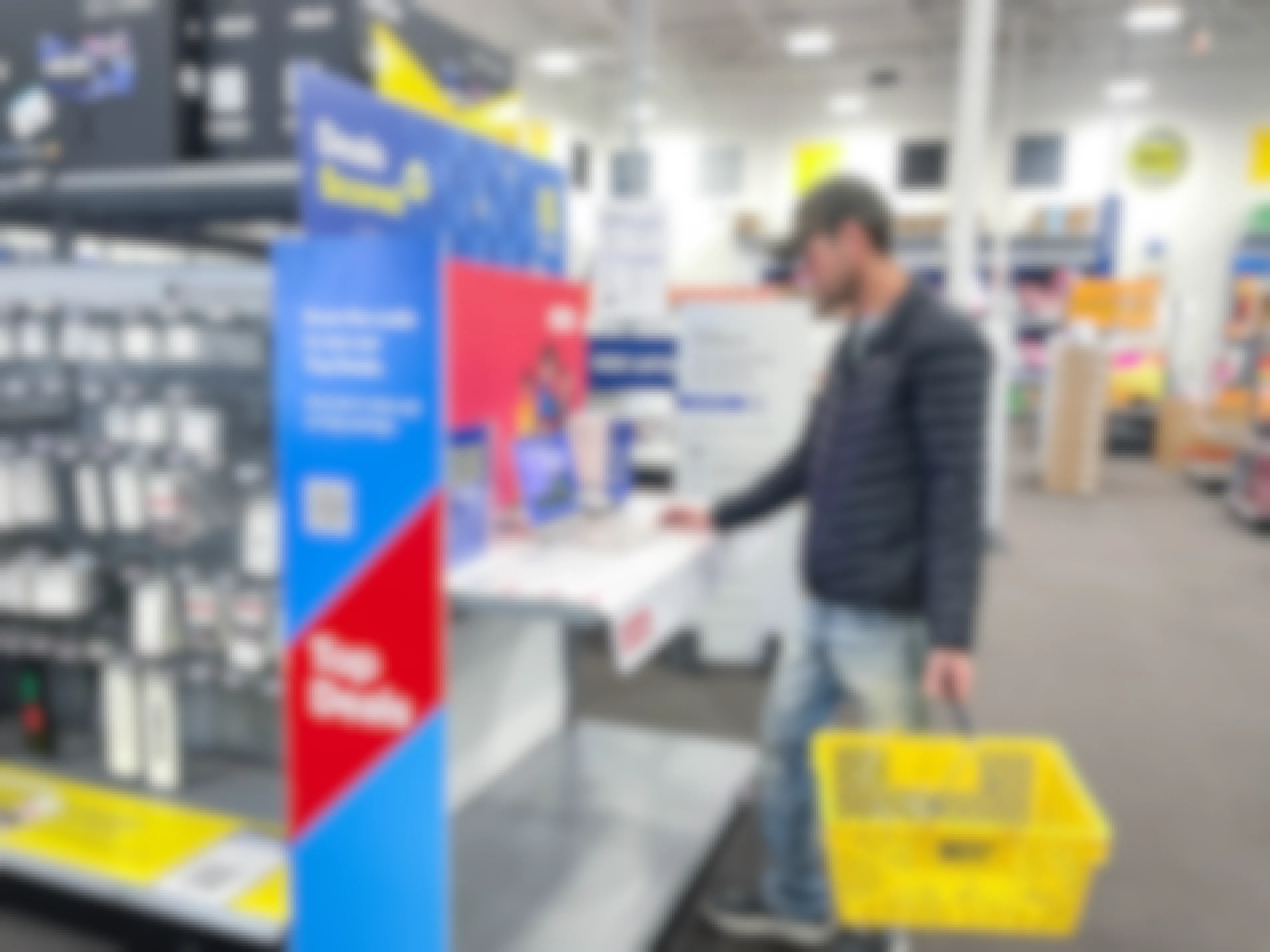 a person looking at a laptop by a top deals sign in best buy