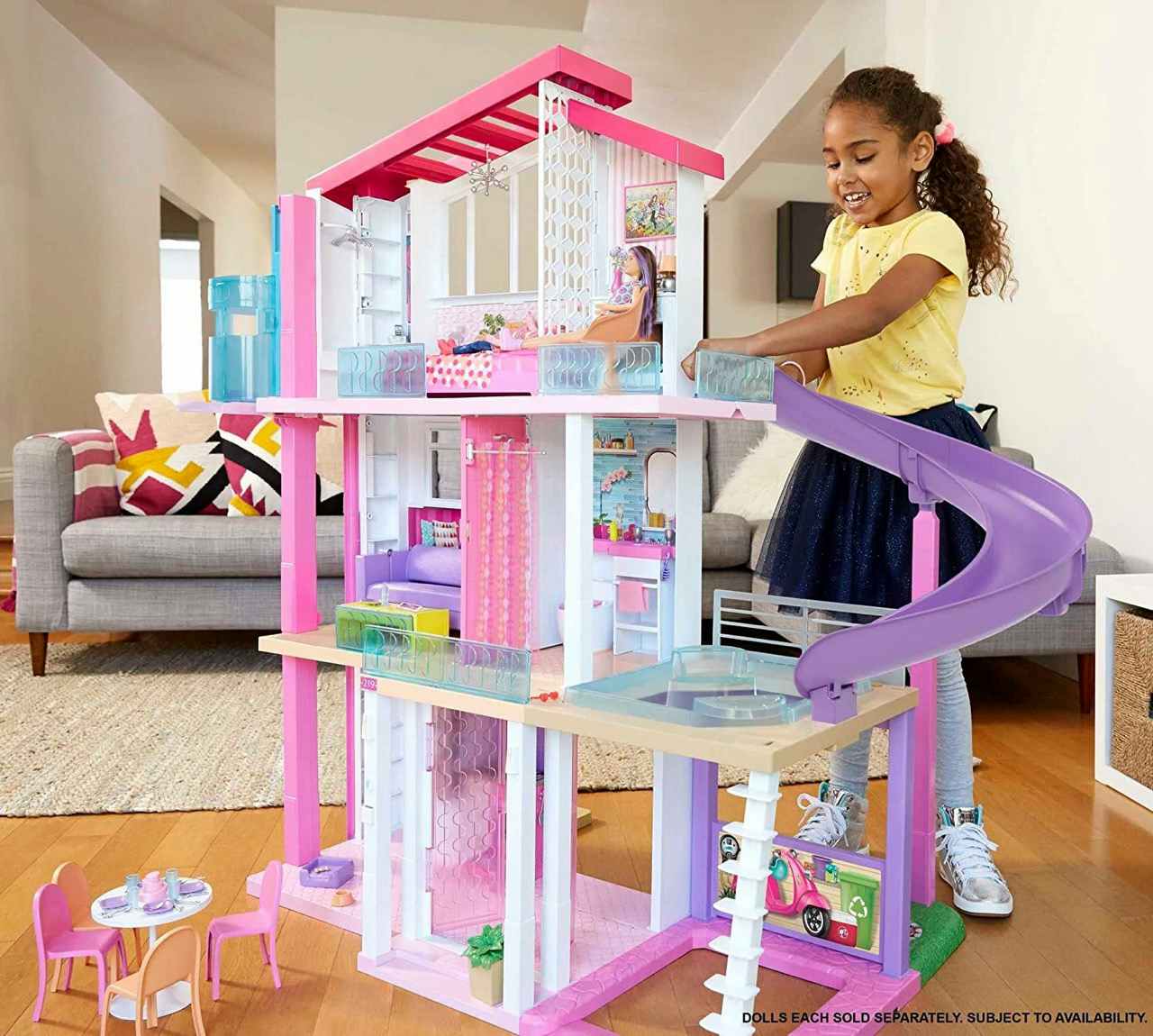 A child playing with a Barbie Dreamhouse Dollhouse