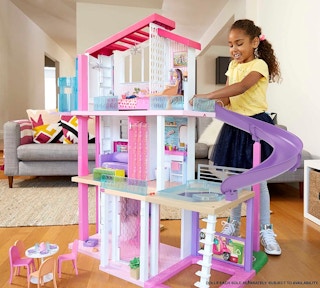 A child playing with a Barbie Dreamhouse Dollhouse