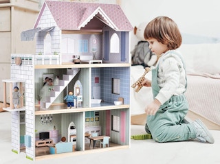A child playing with a Giant Bean Wooden Dollhouse
