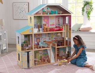 A child playing with a KidKraft Majestic Mansion