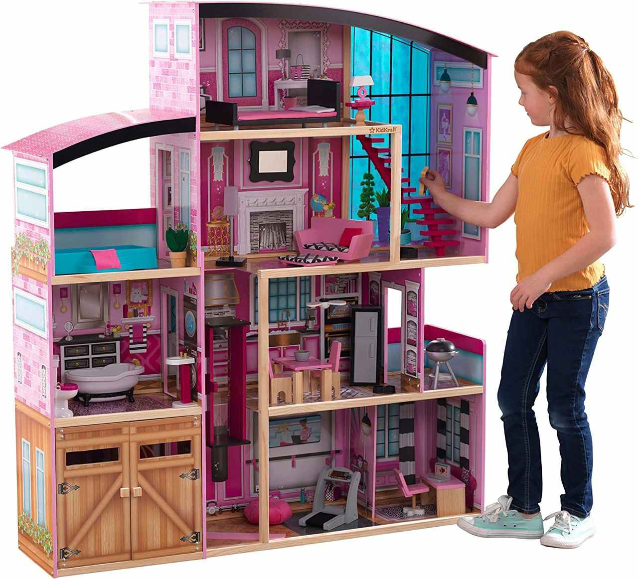 A child playing with a KidKraft Shimmer Mansion Wooden Dollhouse