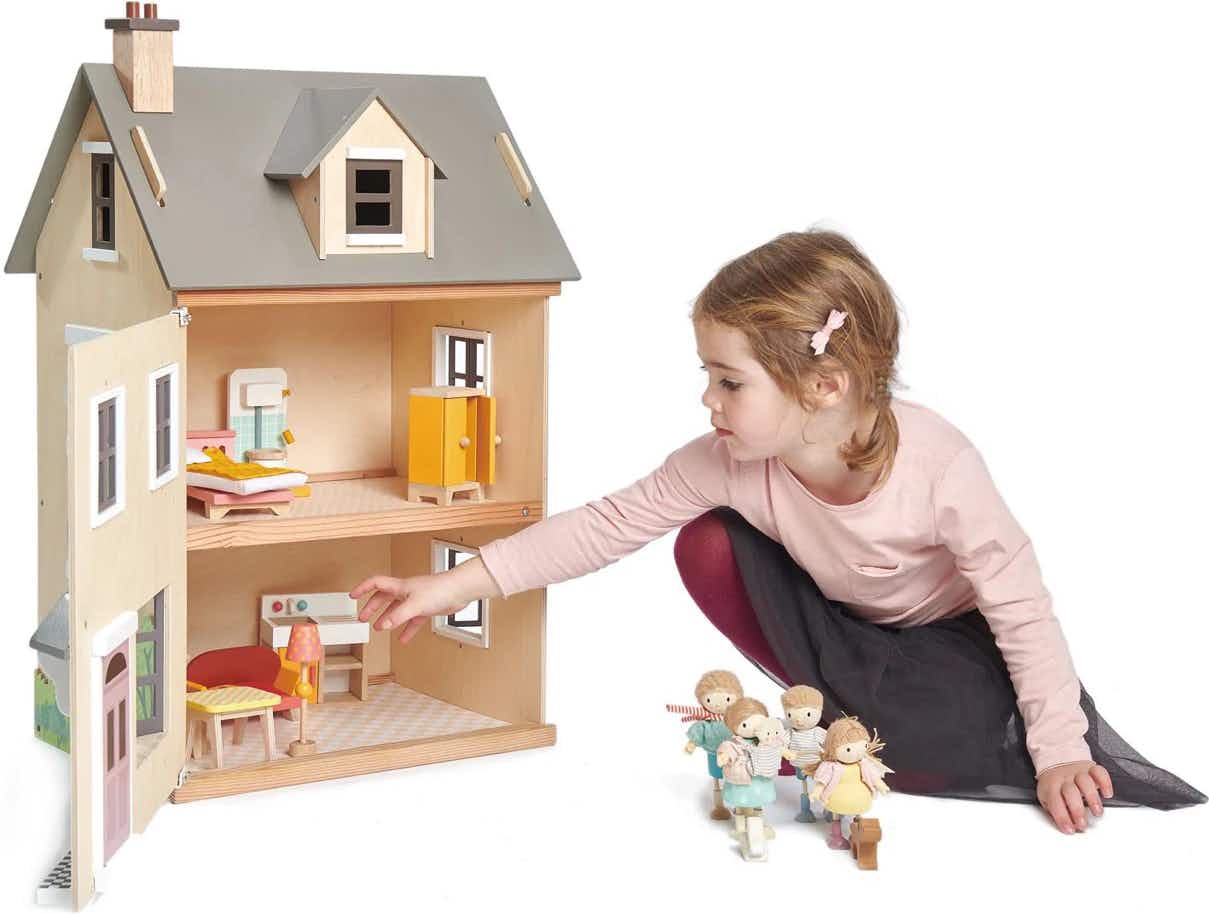A child playing with a Tenderleaf Toys Foxtail Villa Dollhouse