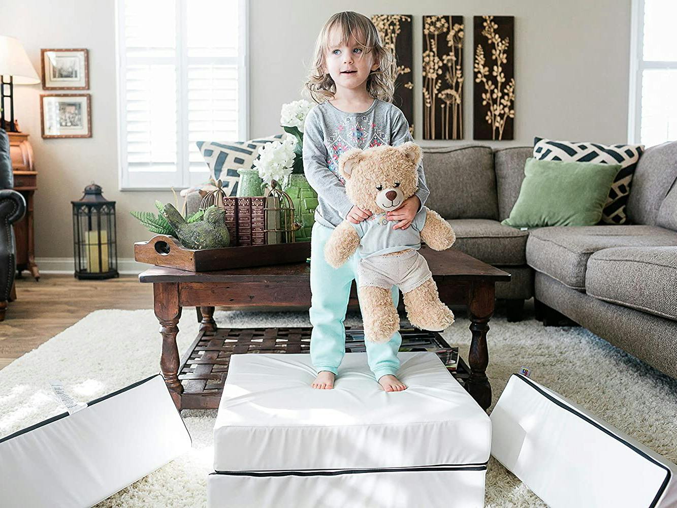 A child playing with a teddy bear on a Foamnasium Blocksy Mini foam play couch