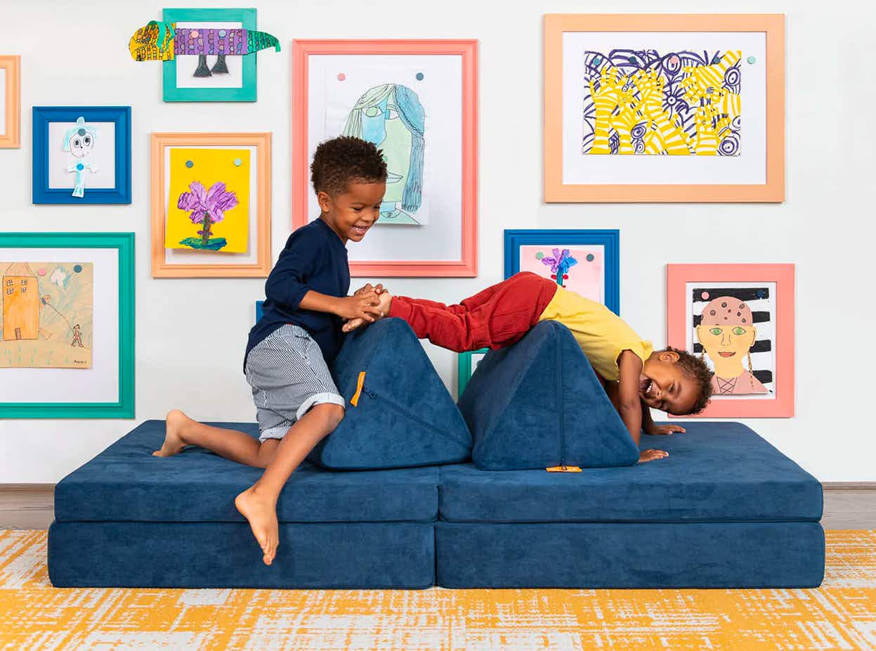 Two kids playing on a Nugget foam play couch