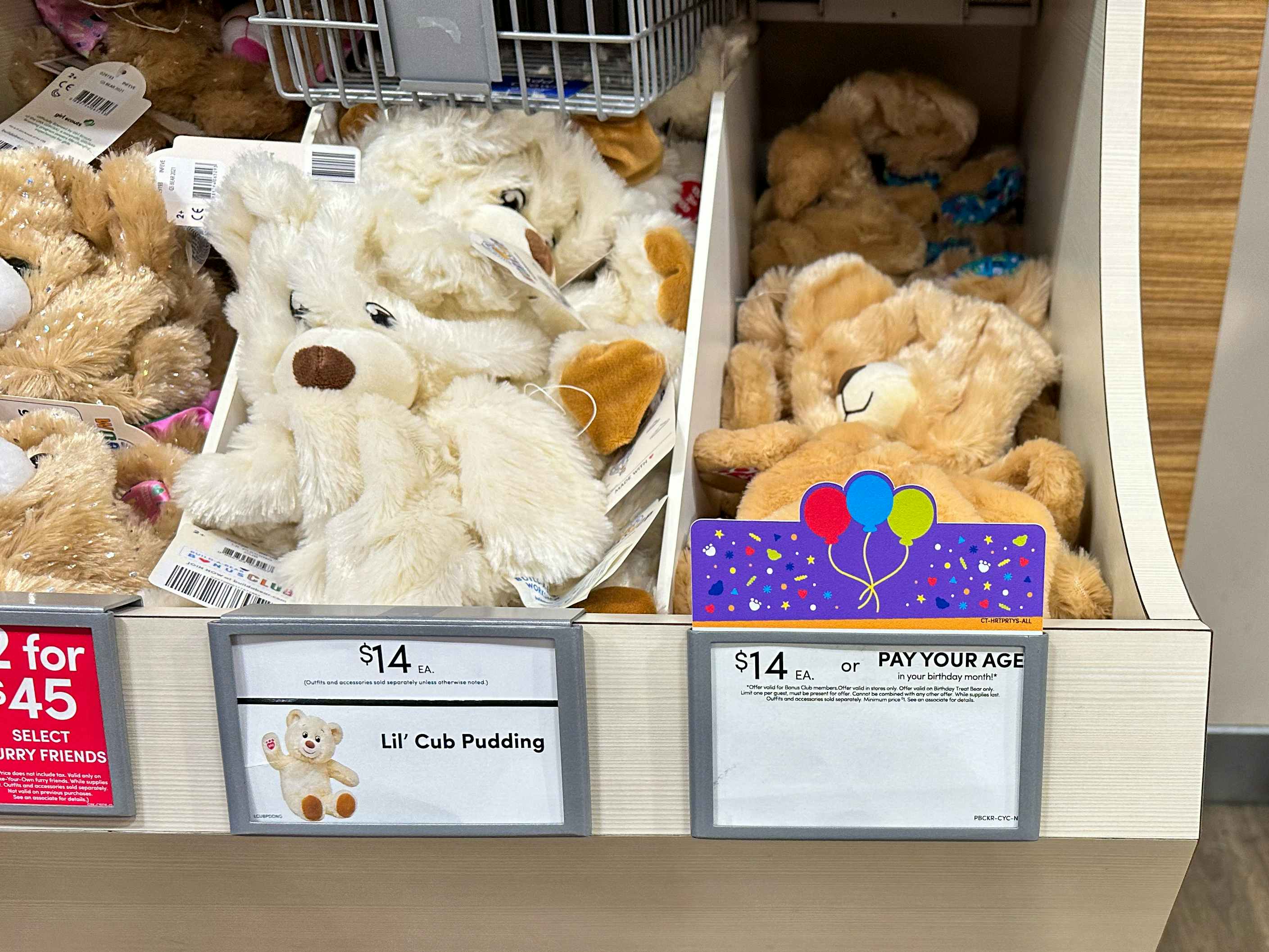 A shelf of Build-A-Bear's Birthday Bears with the price of $14 or Pay Your Age