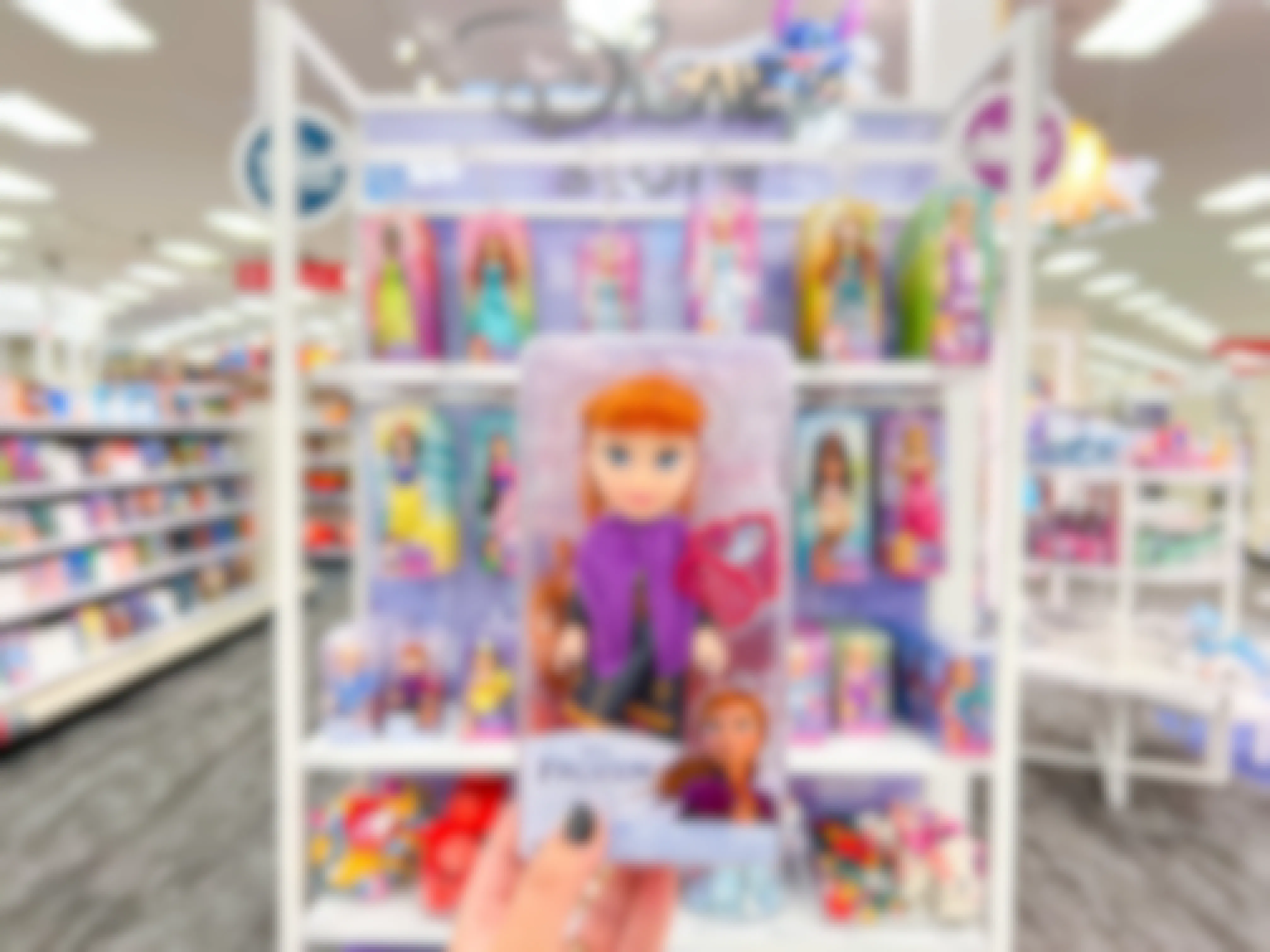 a hand holding up a disney frozen petite anna doll at Target