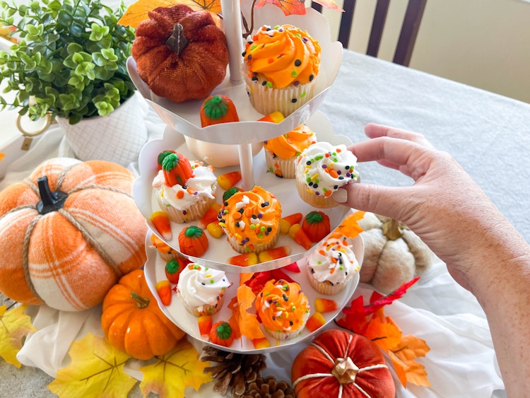 a tiered tray of fall themed cupcakes