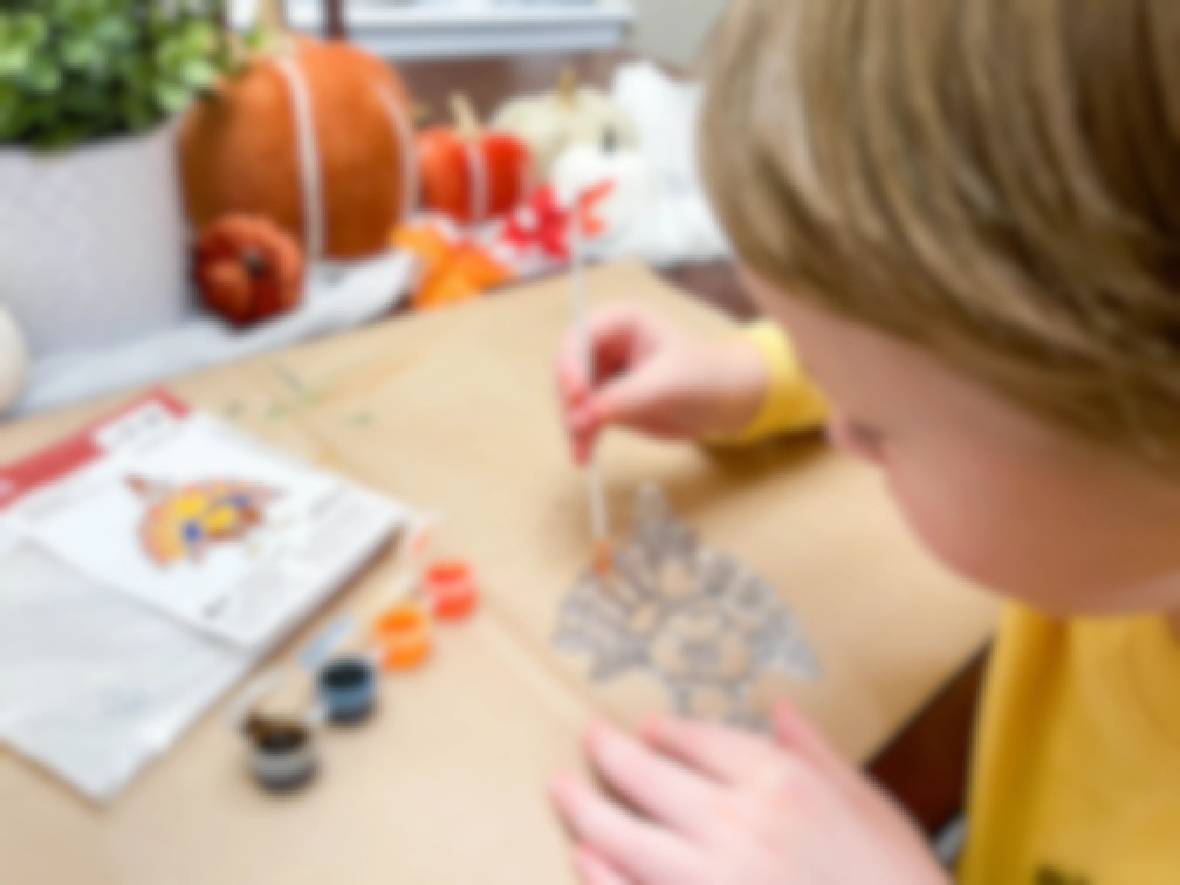 a young child painting a thanksgiving michaels suncatcher crafts