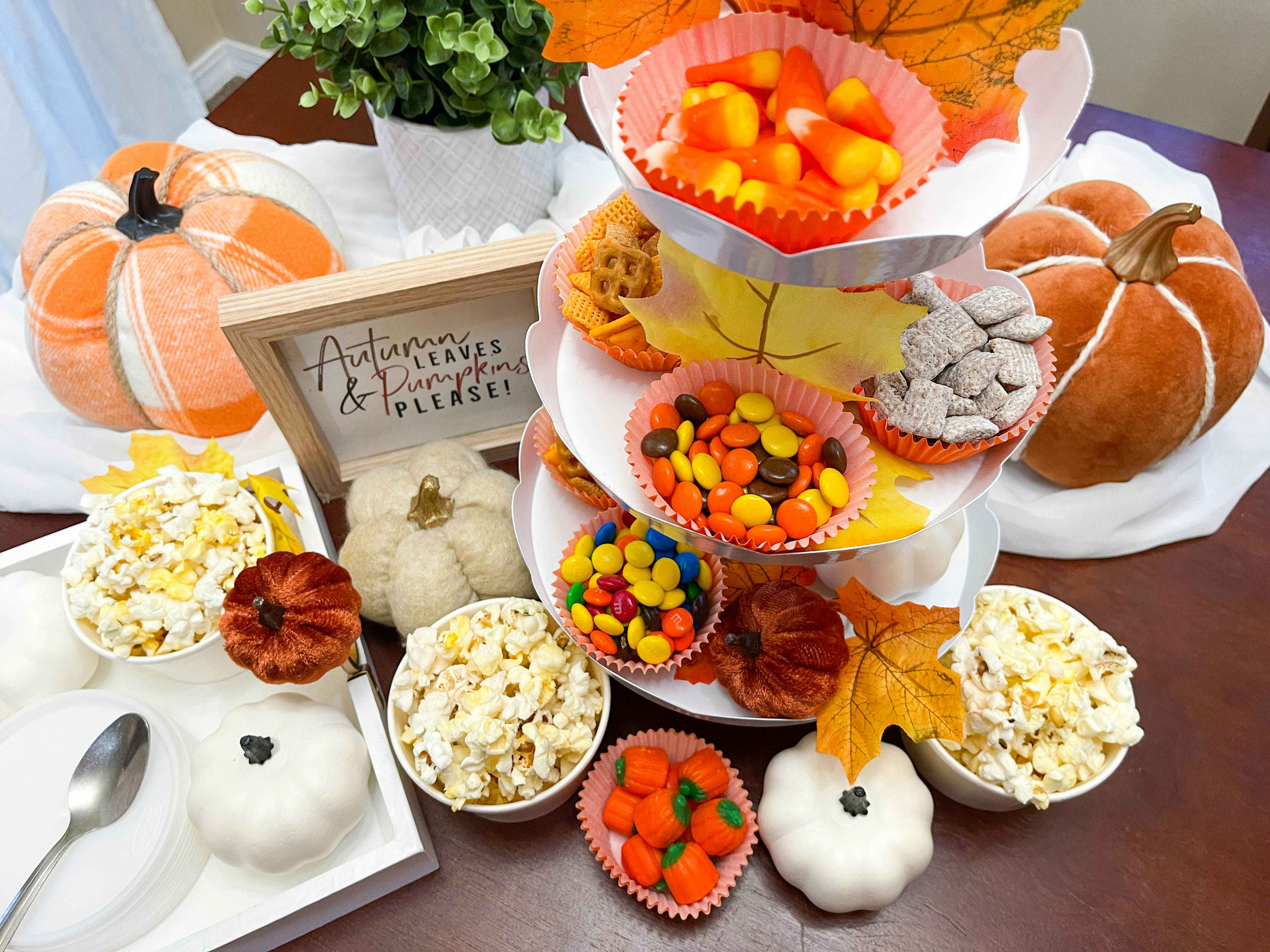 a tiered tray of popcorn and fall snacks on a table