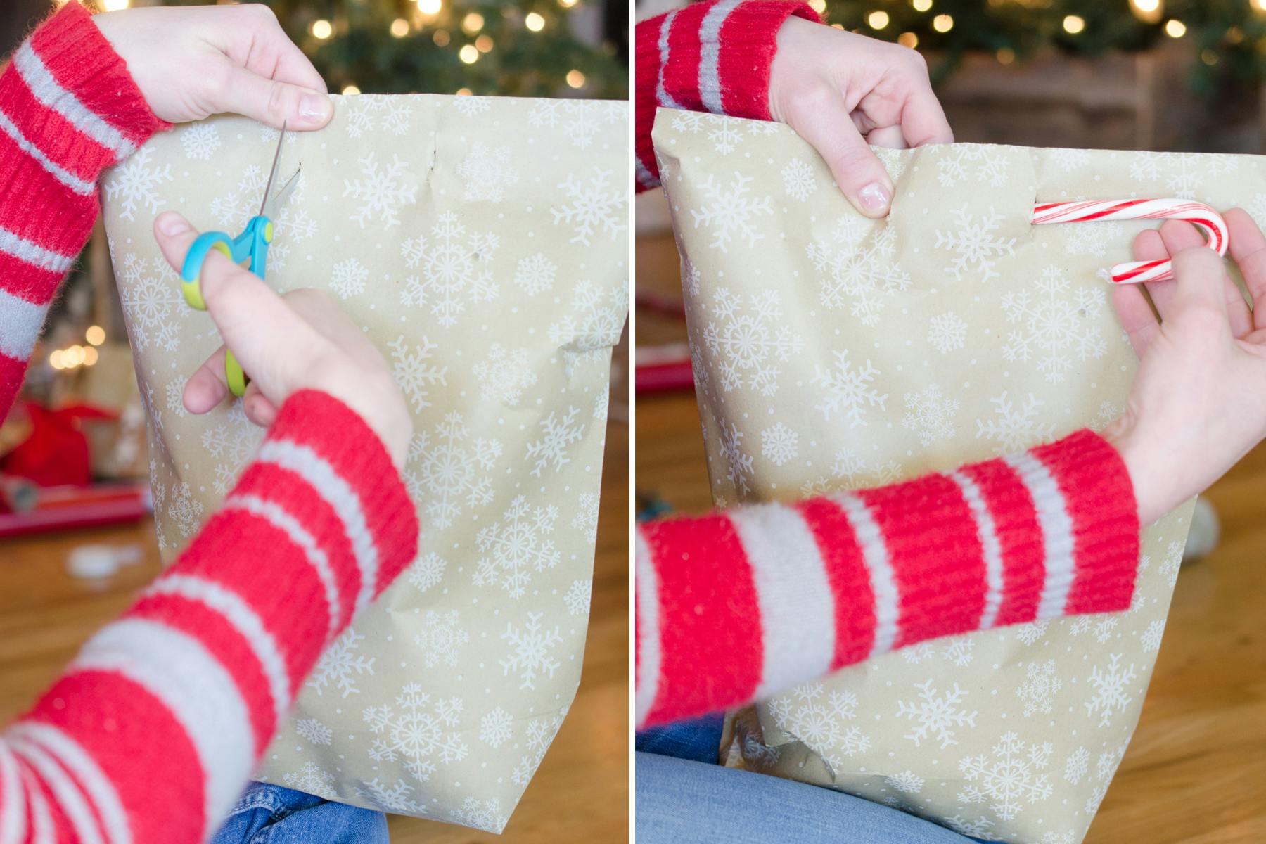 A person cutting holes in a diy wrapping paper bag and inserting a candy cane to close it. 