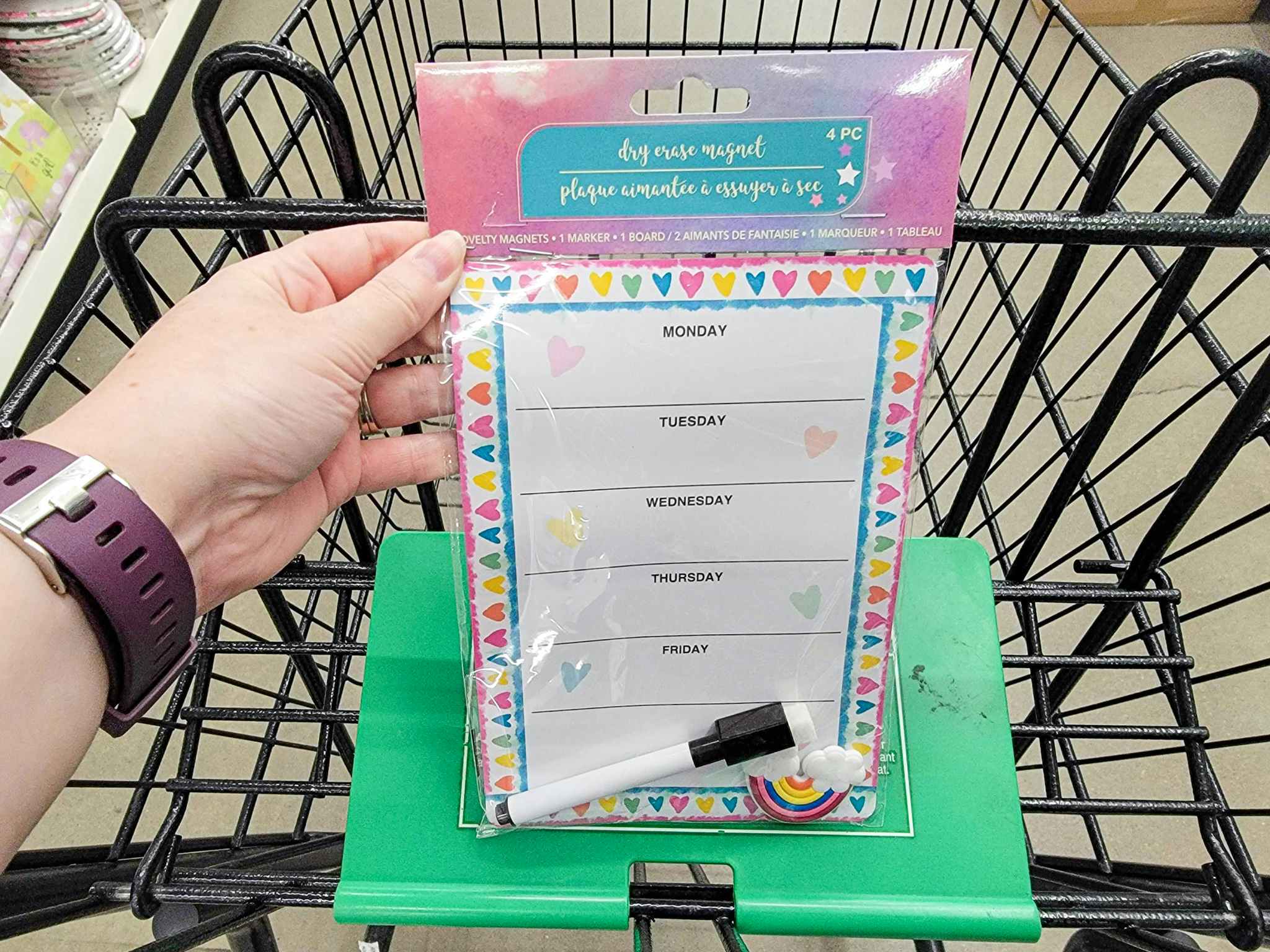 hand holding a dry erase magnetic planner in a cart