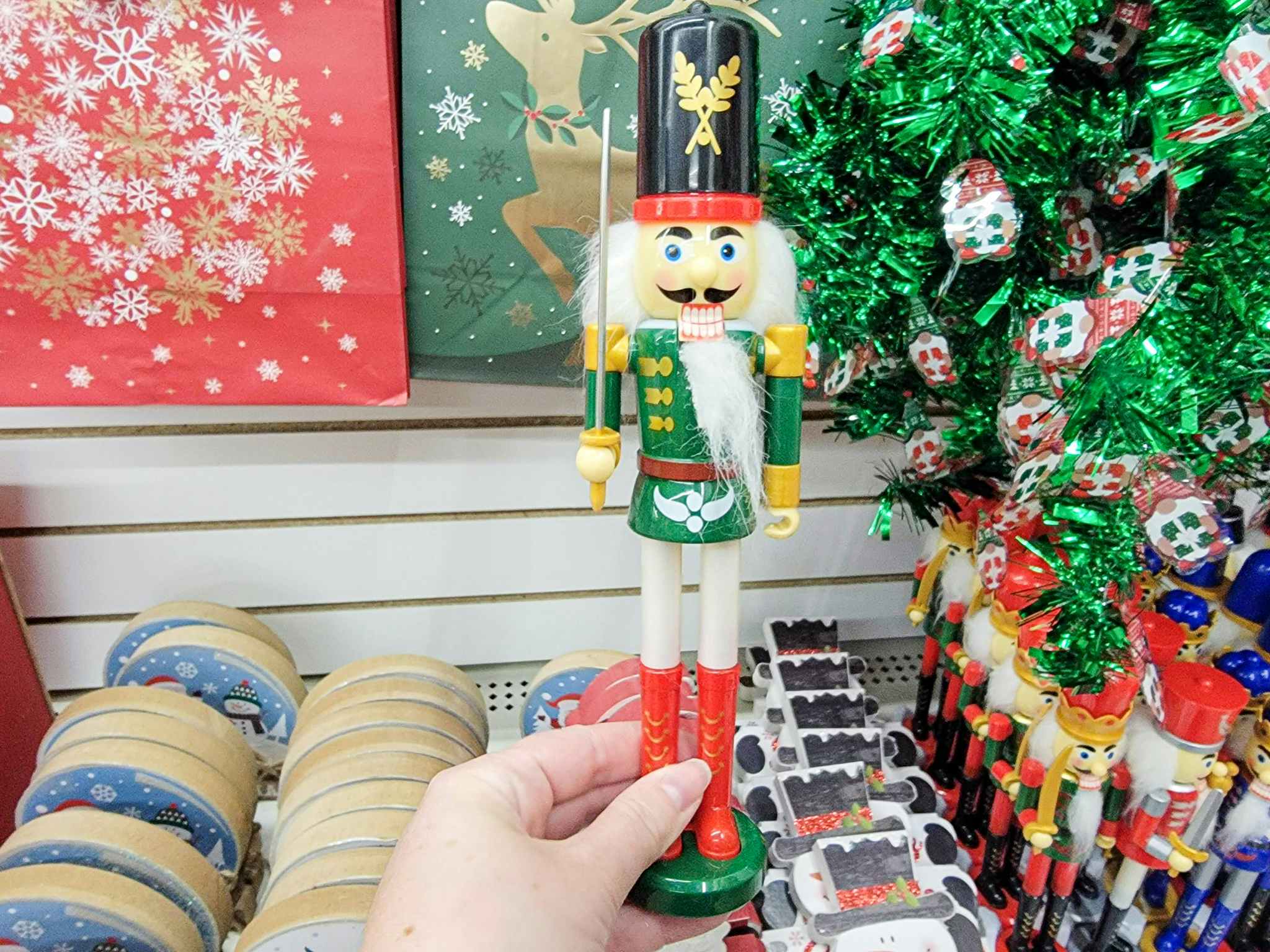 hand holding a nutcracker with a green jacket