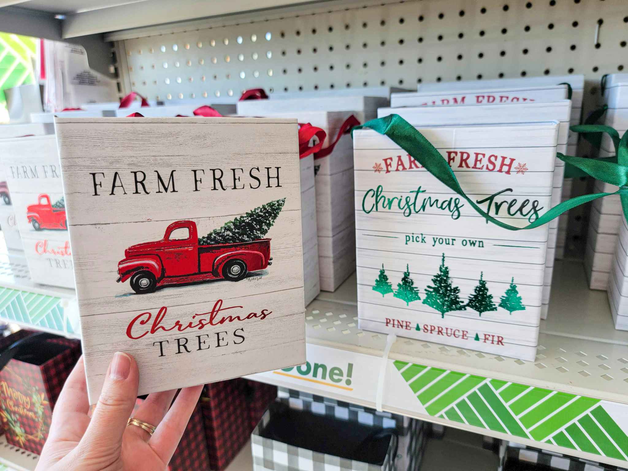 hand holding a small gift bag that says farm fresh christmas trees