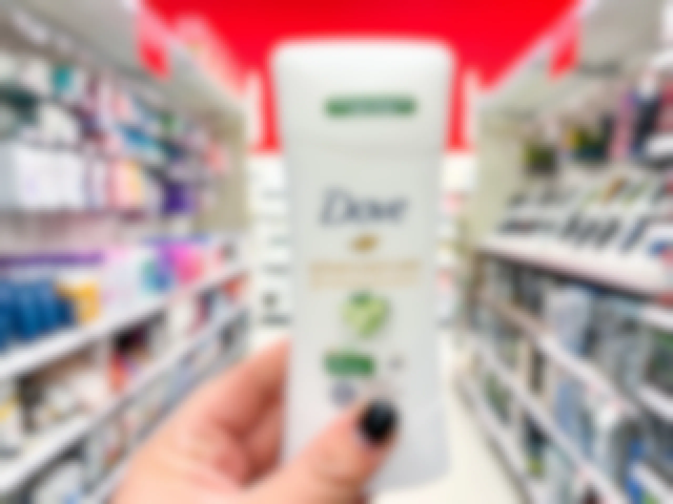 Hand holding Dove Deodorant stick down the center of an aisle at Target